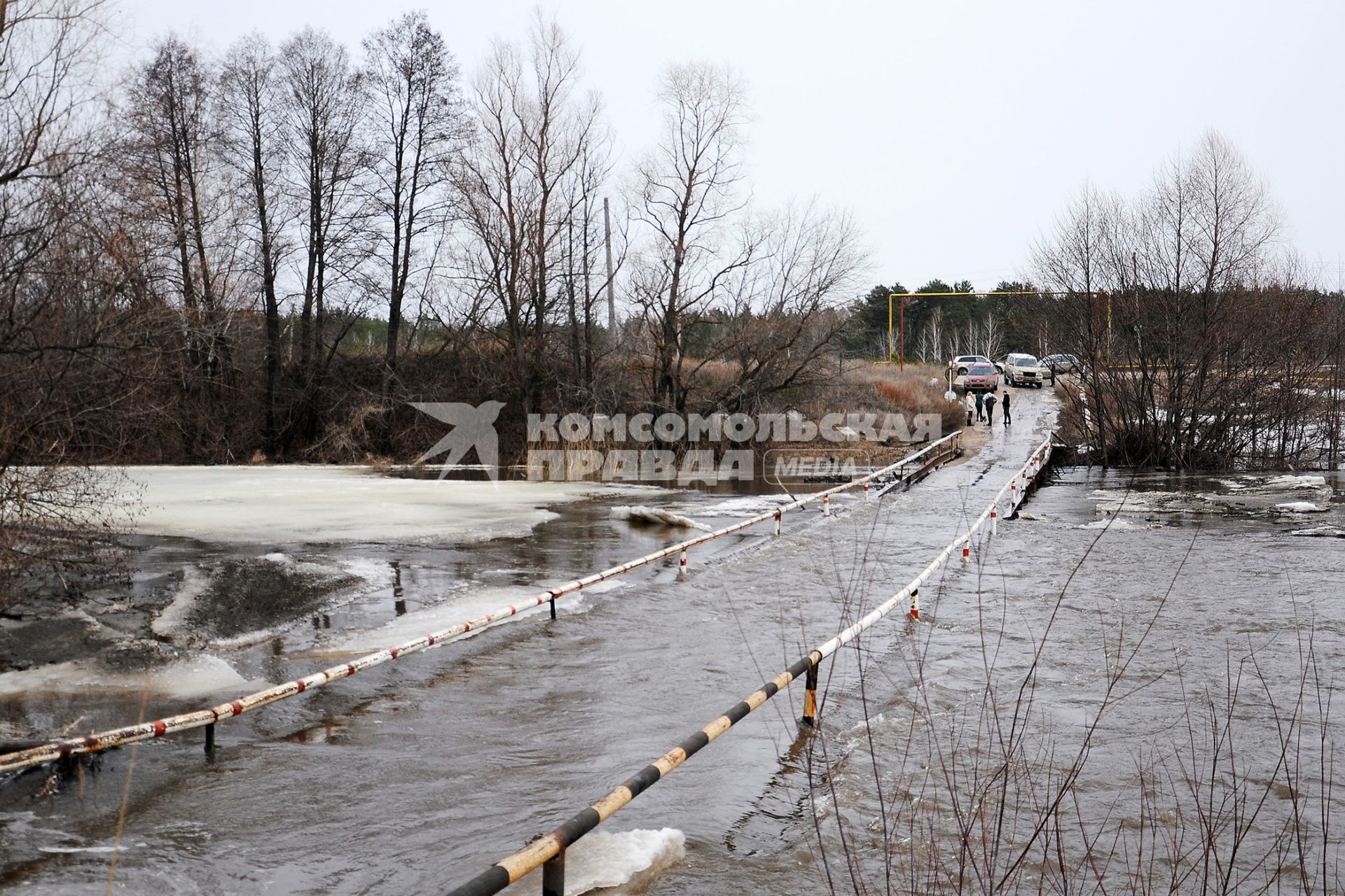 Автомобили стоят у затопленного моста.