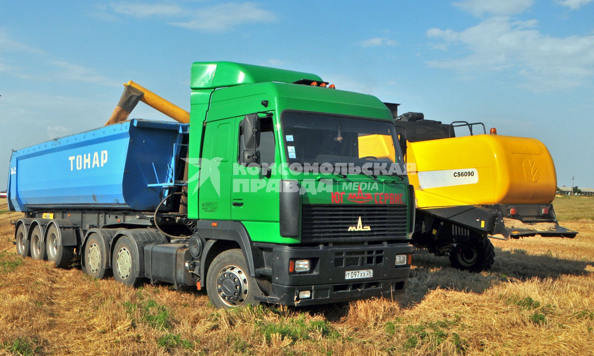 Уборка урожая. Зерноуборочный комбайн `New Holland CS 6090` и рефрижератор `МАЗ` ТОНАР`.