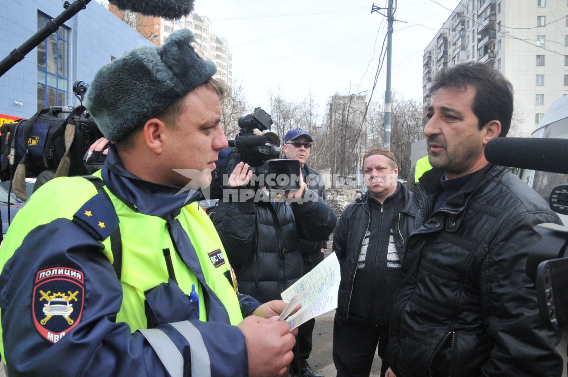 Сотрудники Госавтоинспекции совместно с ФМС провели рейд по выявлению незаконных маршрутных такси. На снимке: сотрудник ДПС и водитель маршрутногшо такси.