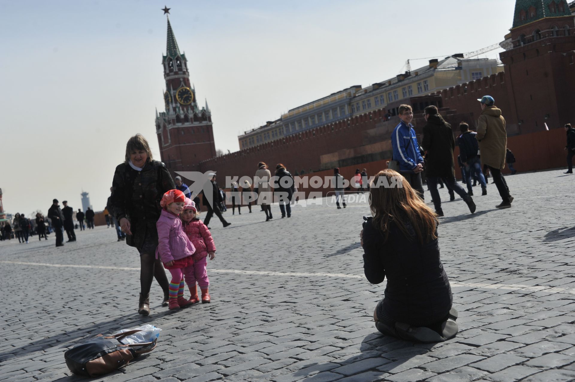 Туристы на Красной площади. На снимке: девушка фотографирует детей.