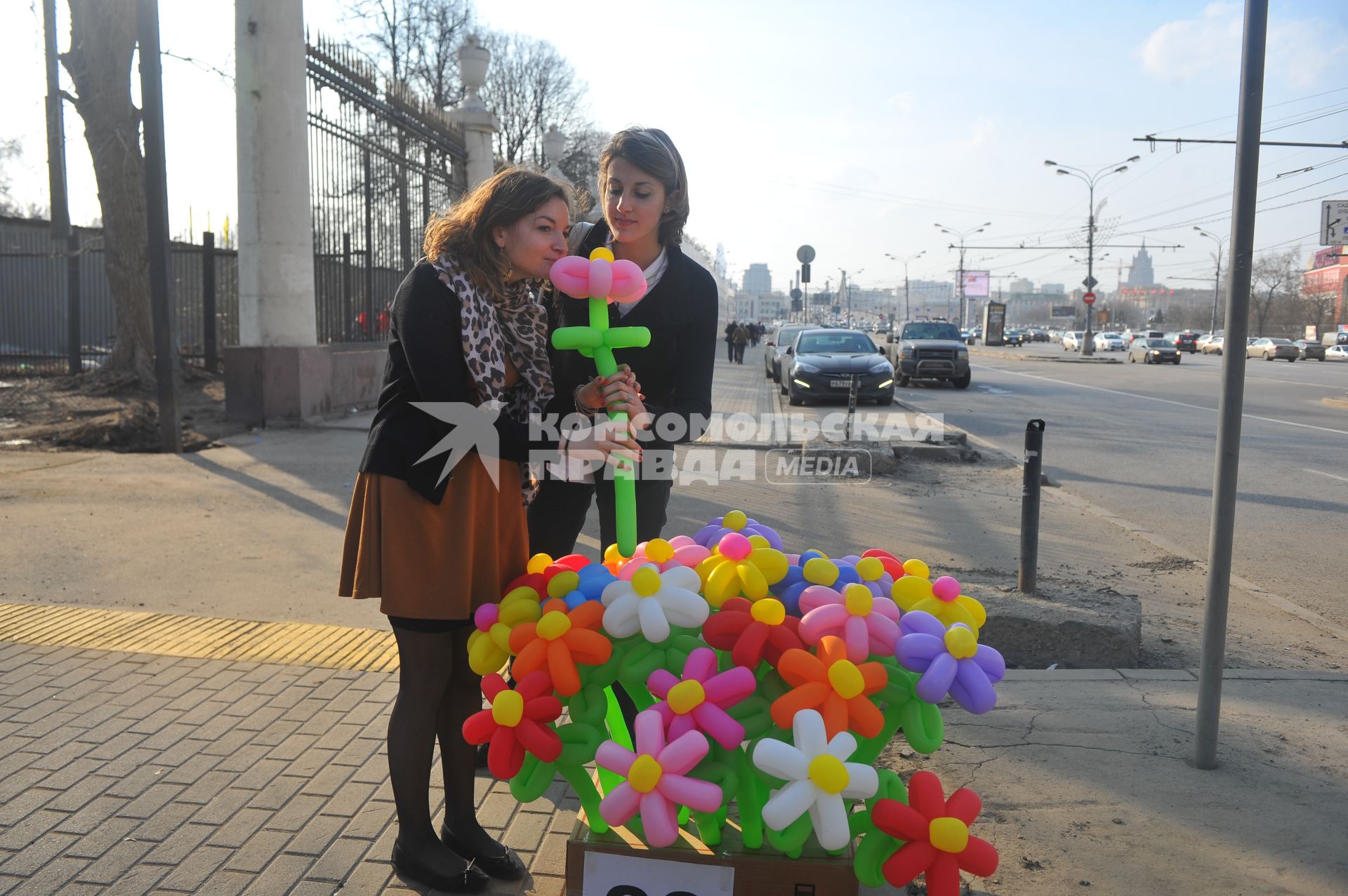 Девушки у коробки с надувными цветами.