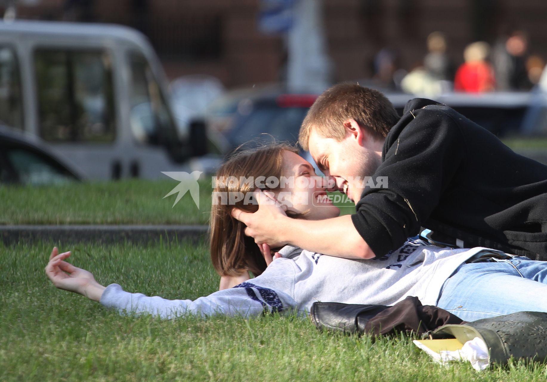 Парень с девушкой лежат на траве