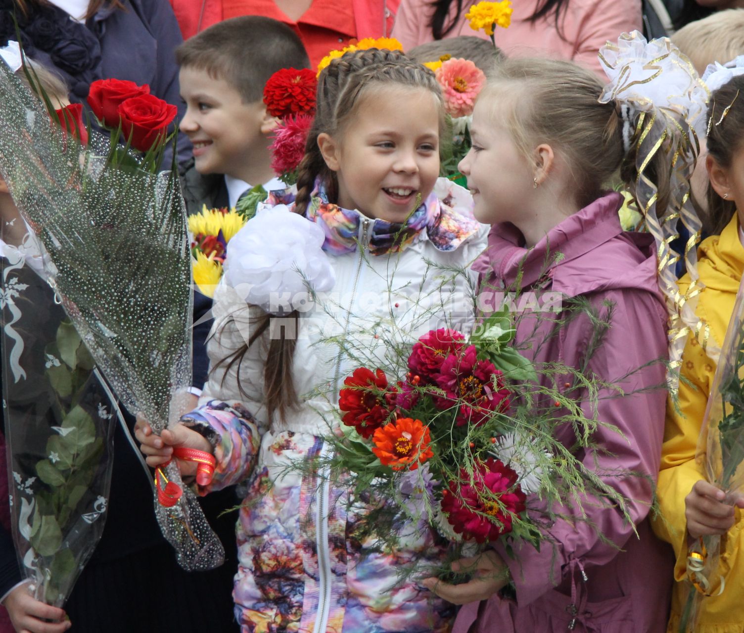 Две девочки держат в руках цветы