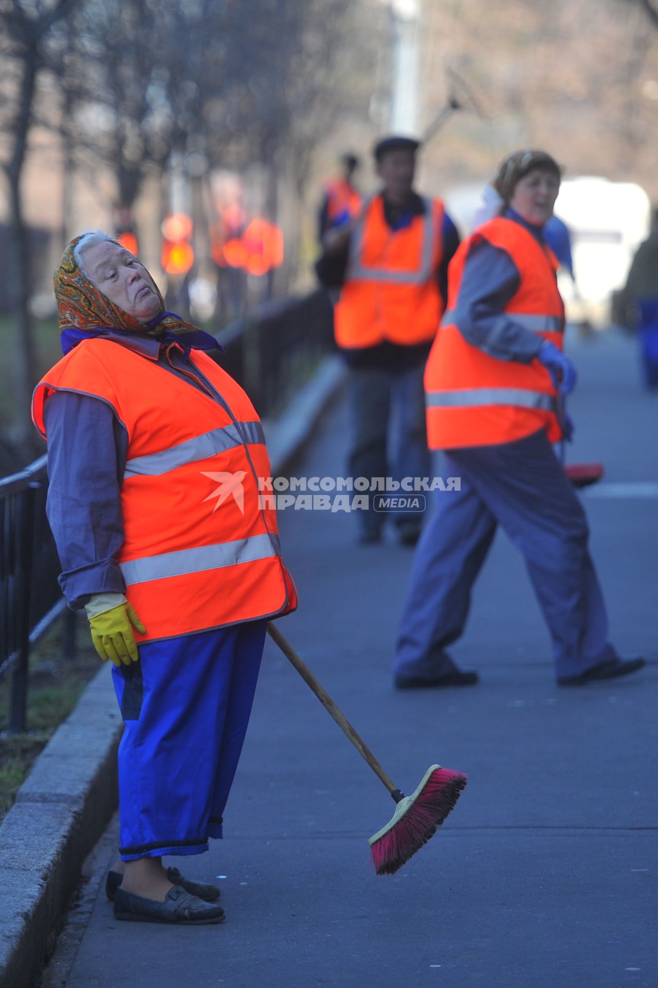 Женщины в спецодежде держит в руках щетку