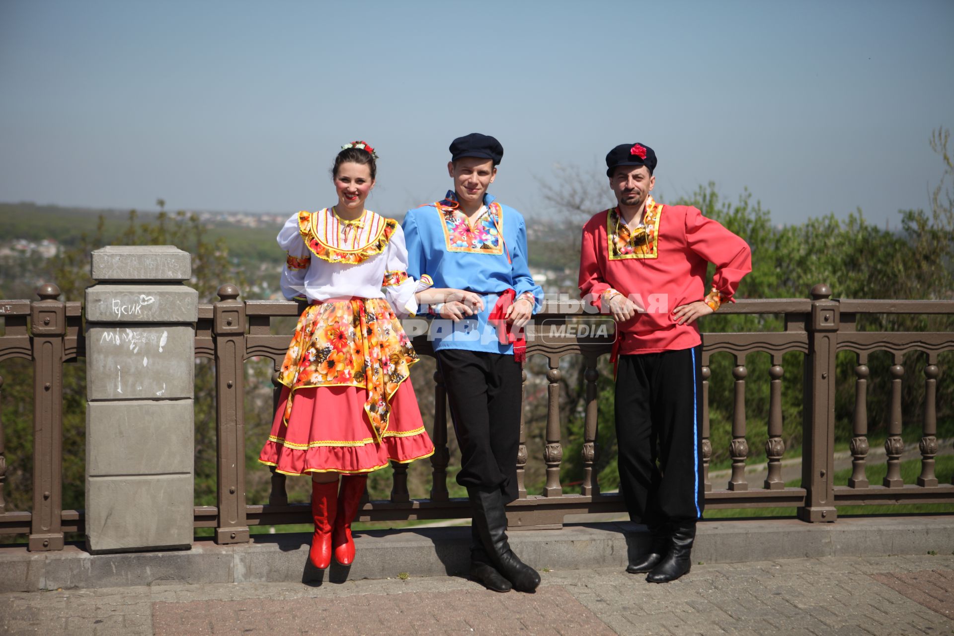 Парни и девушка в традиционных казачьих костюмах