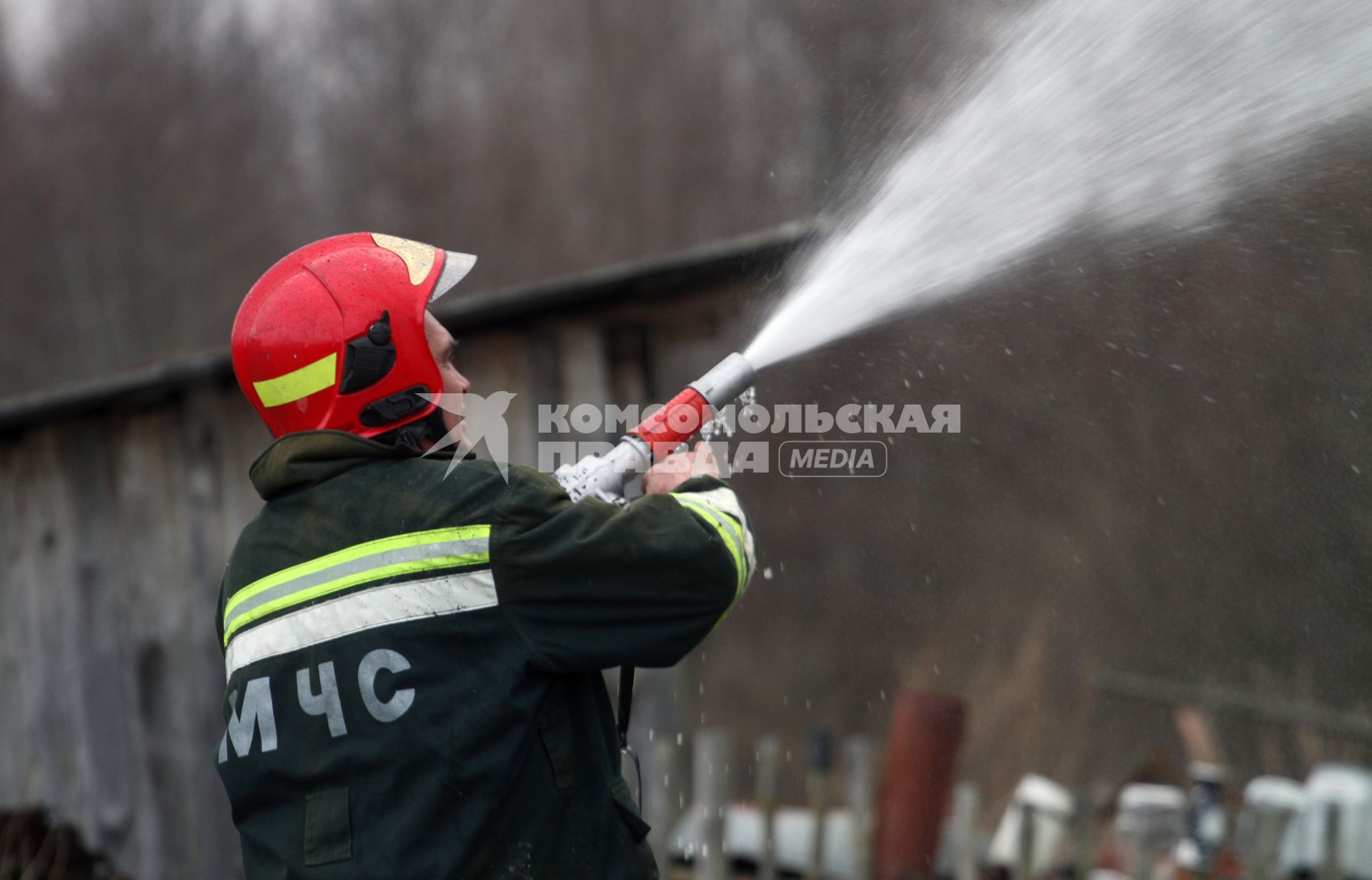 Пожарный тушит огонь