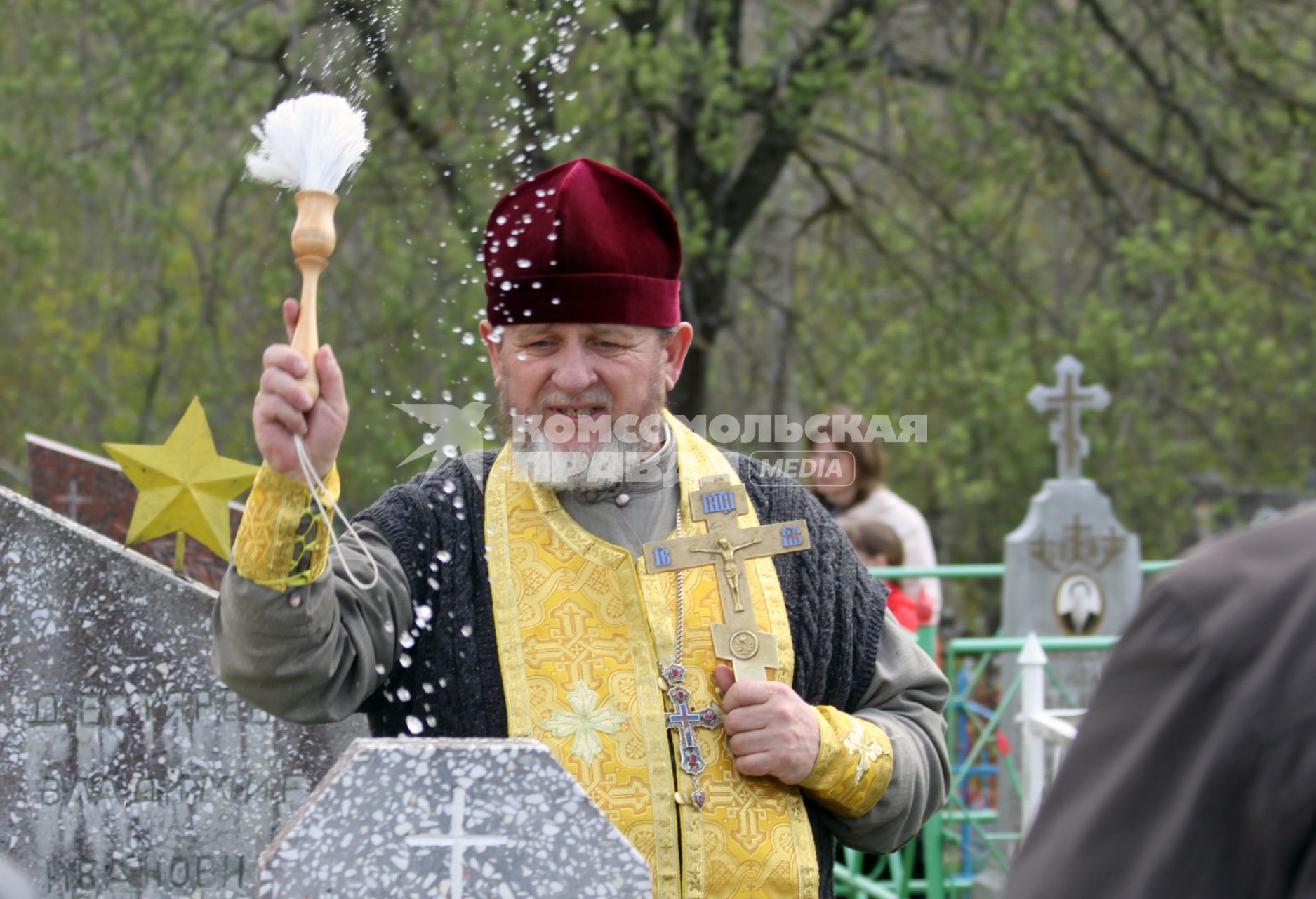 Священник Валентин Шелест освящает могилы на кладбище