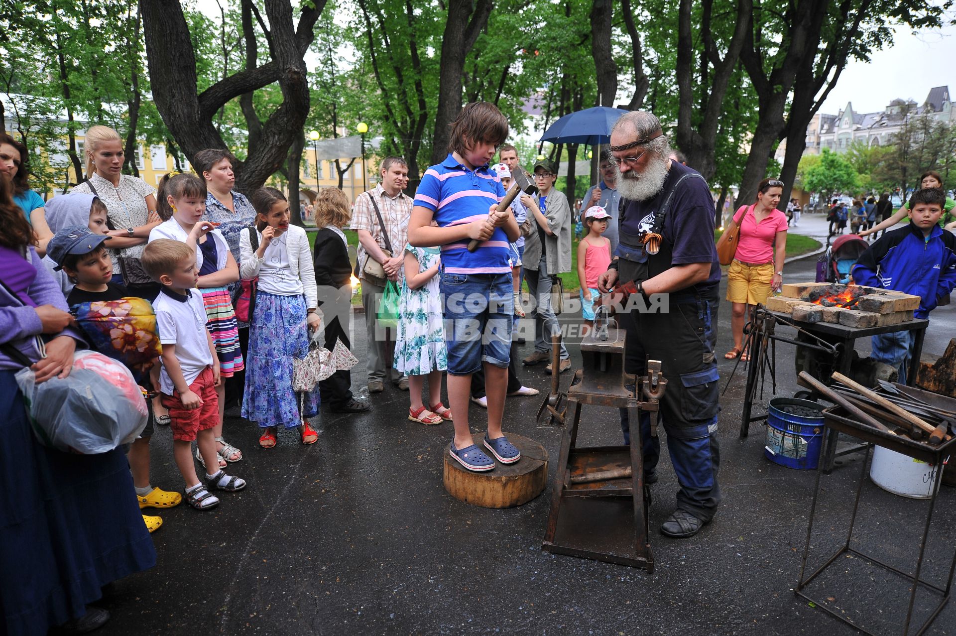 Акция `\'Ночь в музее 2013`. На снимке: кузнец и мальчик.