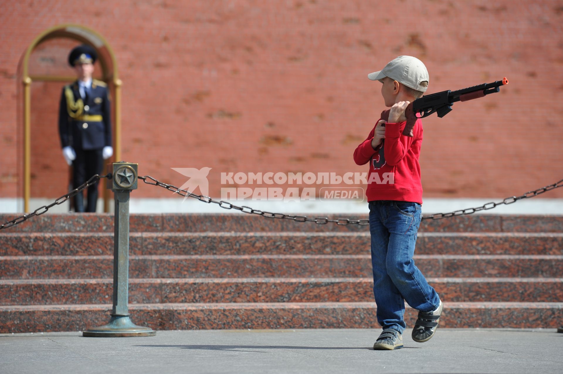 Александровский сад. На снимке: ребенок с игрушечным оружием в руках на фоне солдата стоящего на посту № 1.