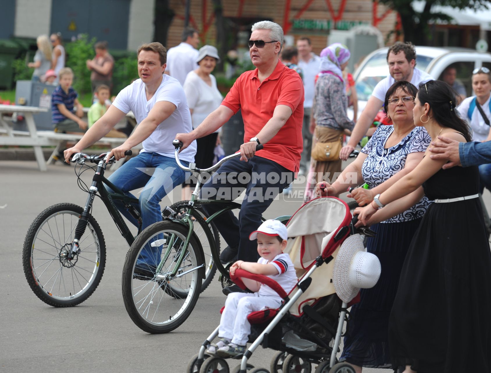 Открытие велопроката в Парке Горького. На снимке: руководитель Департамента транспорта и развития дорожно-транспортной инфраструктуры Москва Максим Ликсутов (слева) и мэр Москвы Сергей Собянин (в центре) едут на велосипедах.