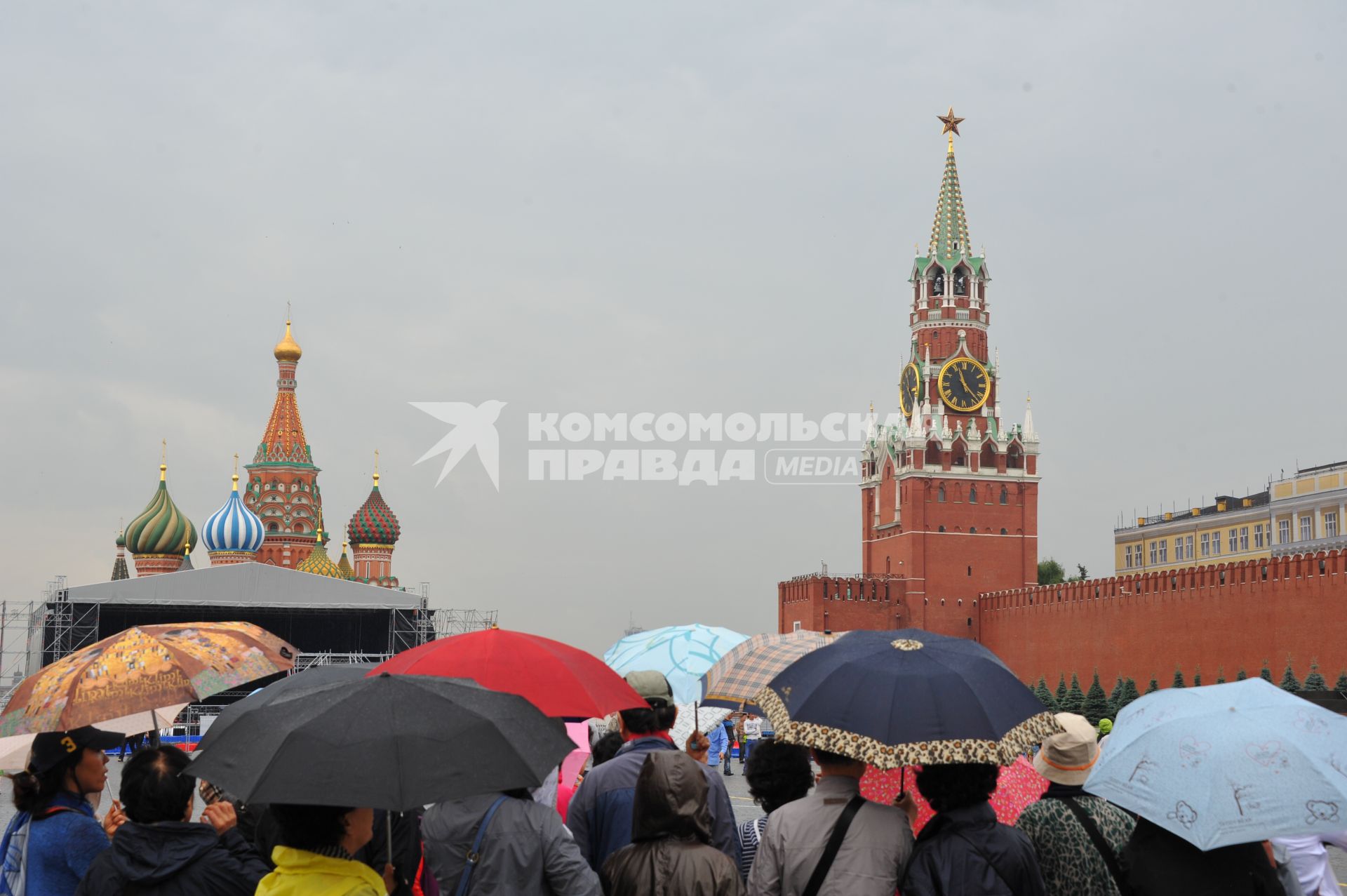 Красная площадь. На снимке: люди под зонтами.