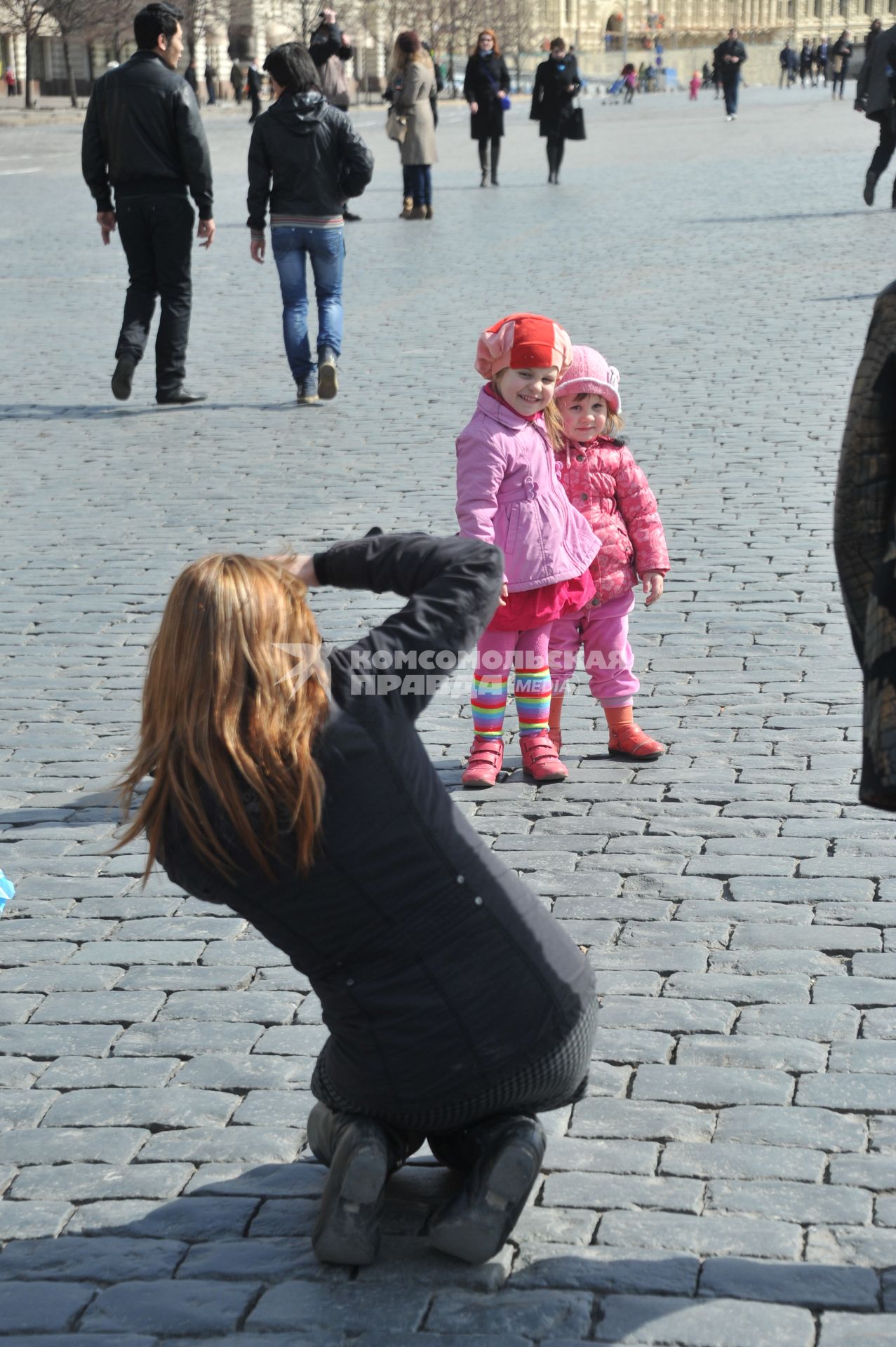 Женщина фотографирует детей.