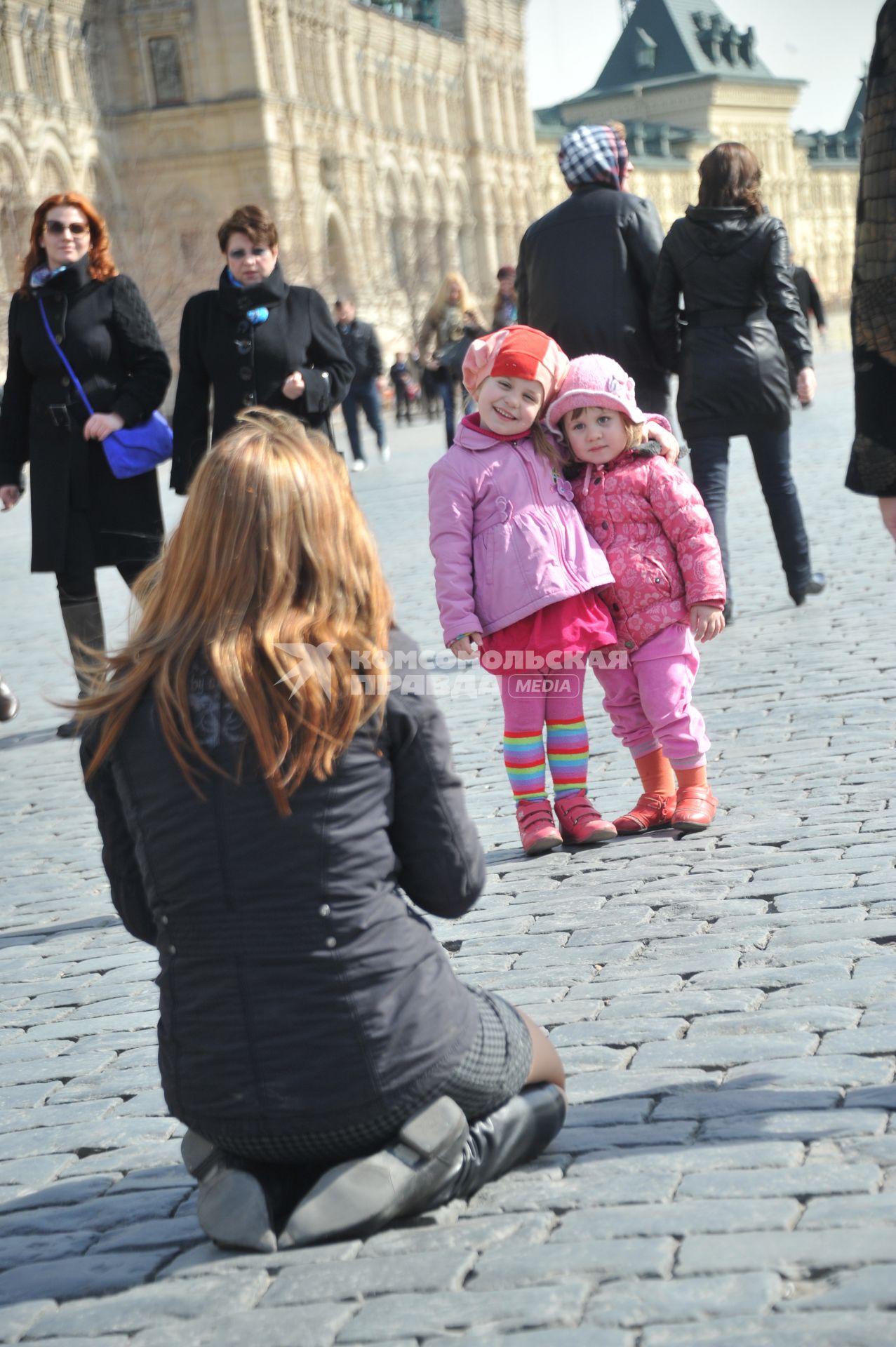 Женщина фотографирует детей.