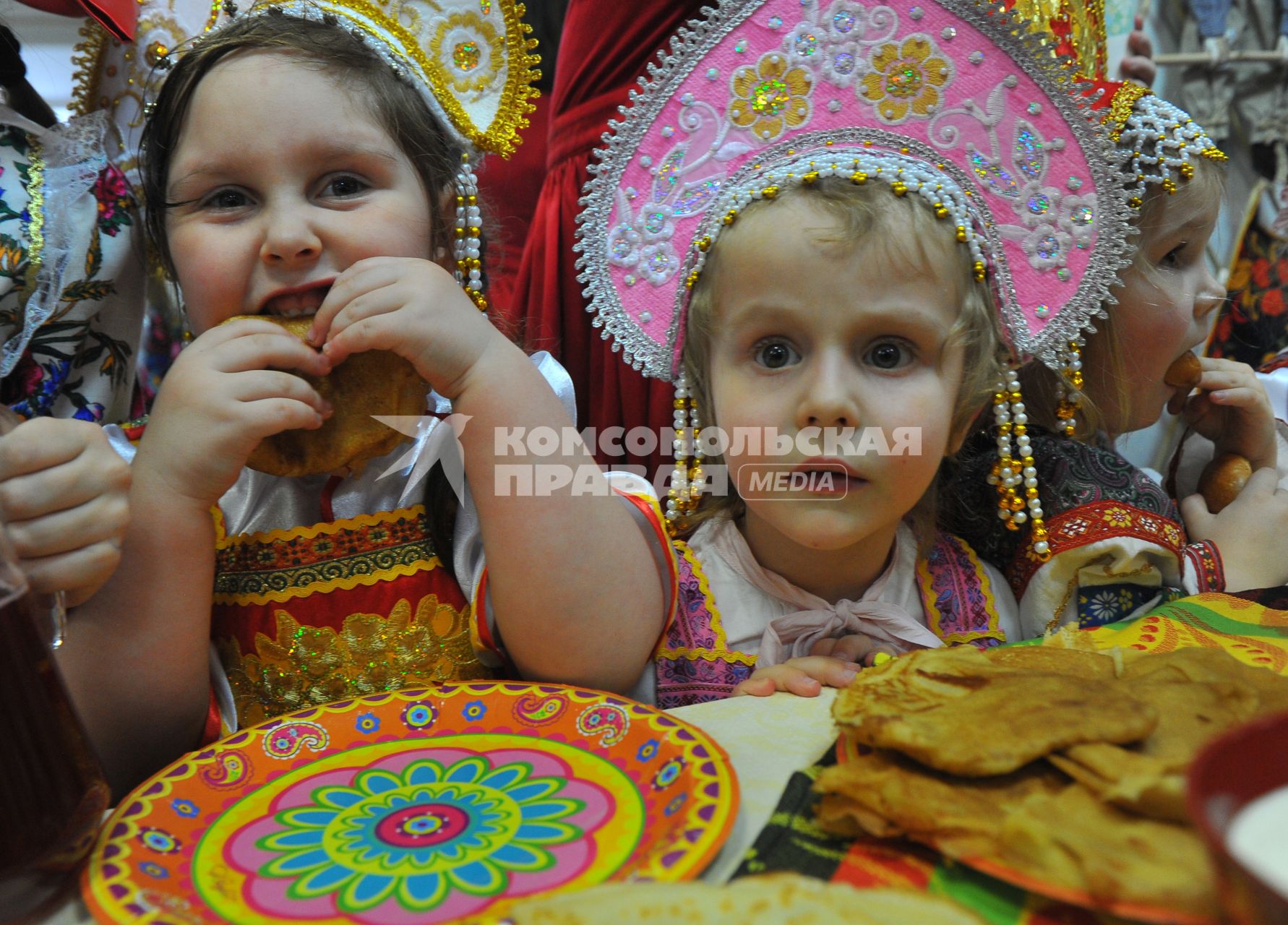 Участники коллектива `Непоседы`угощаются масленичными блинами.