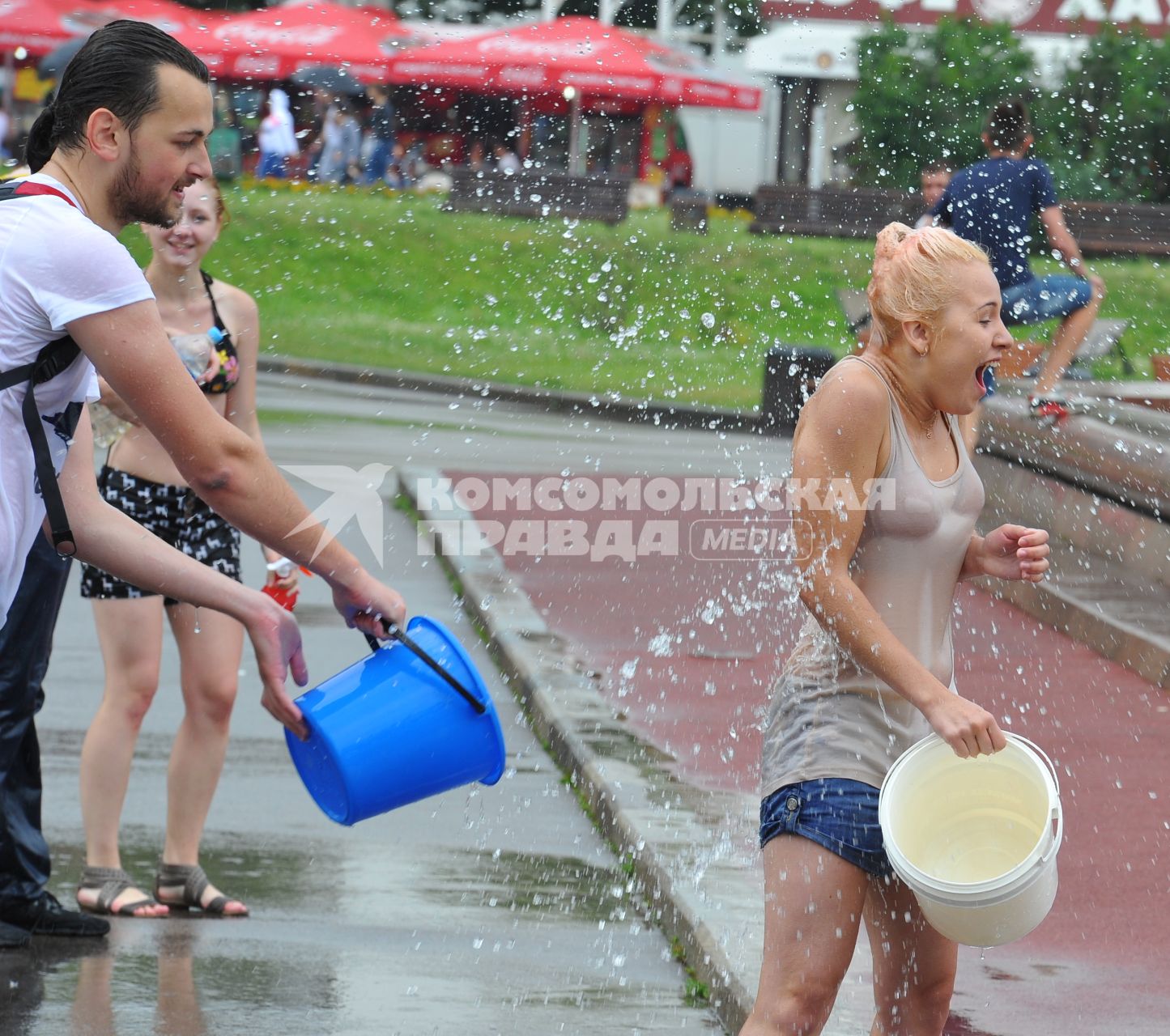 Водная битва на ВВЦ 2013. На снимке: парень обливают  девушку  водой.