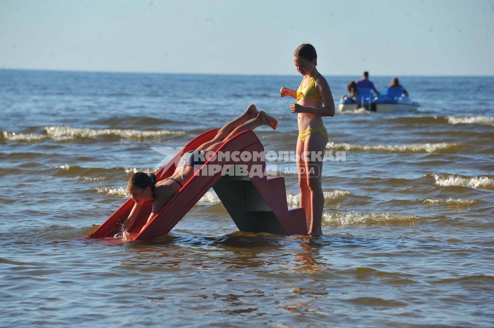 Отдых на море. На снимке: девочки скатываются с горки.