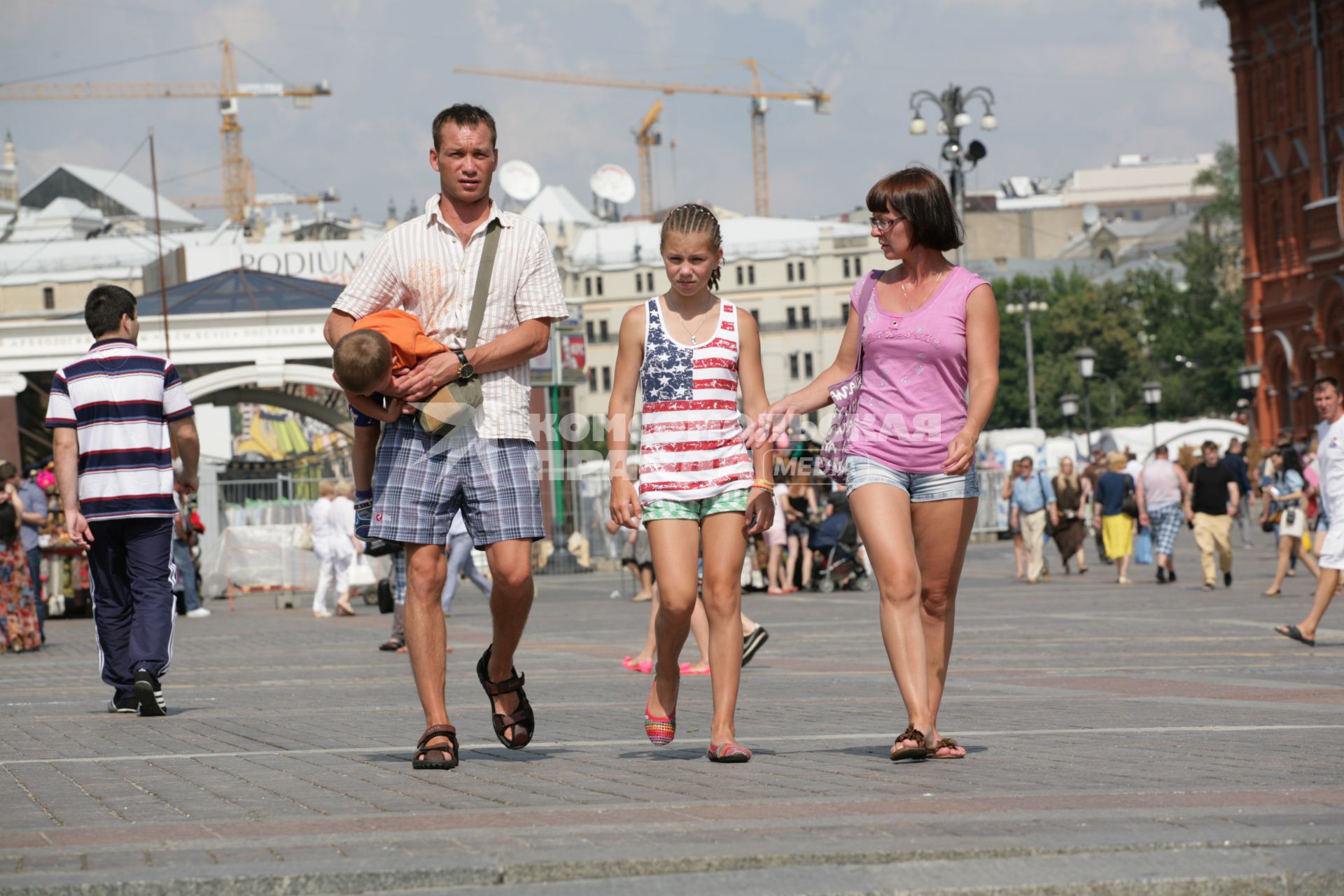 Родители и дети на городской улице.