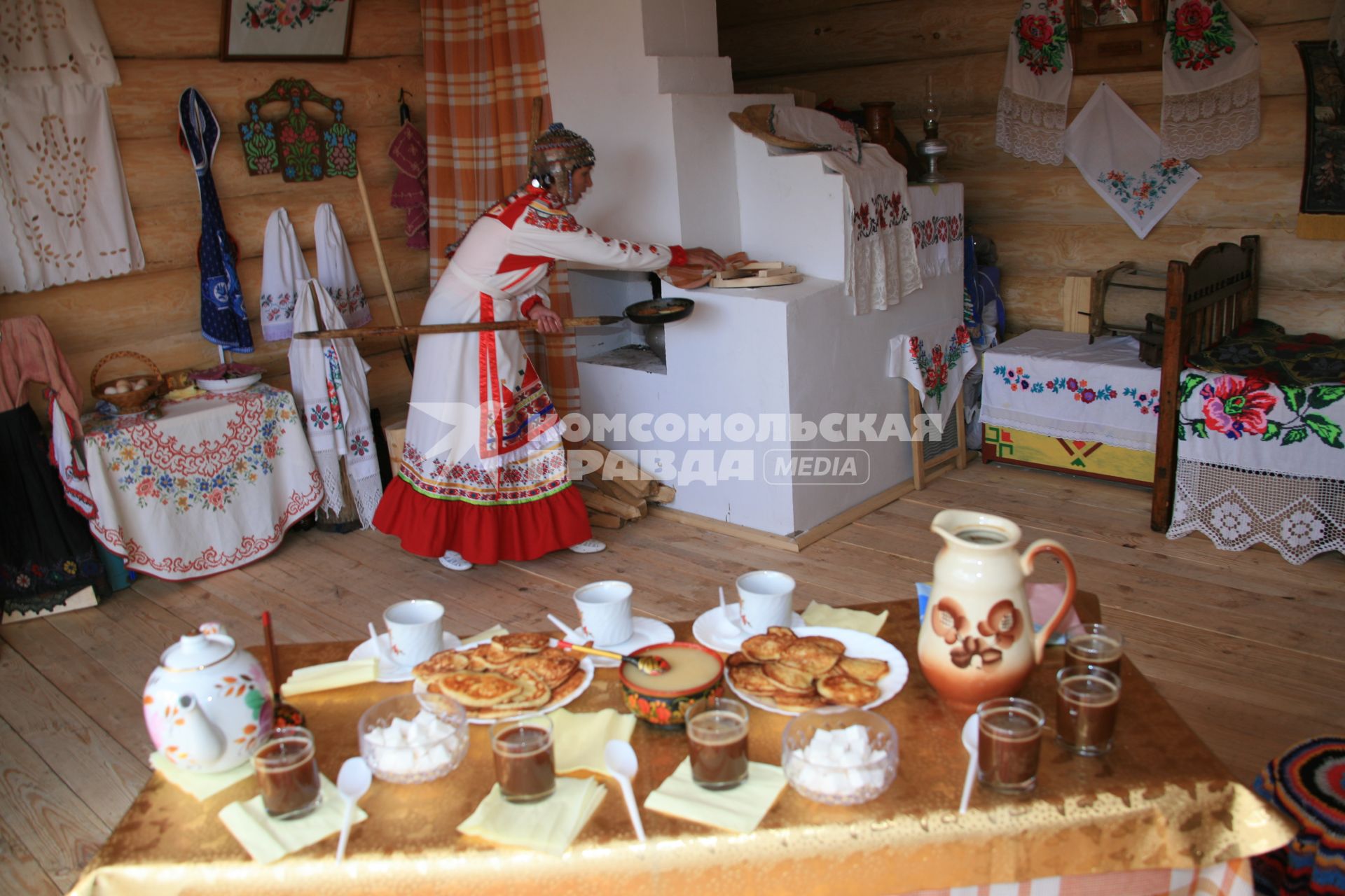 Русские традиции. На снимке: женщина с кочергой у русской печи