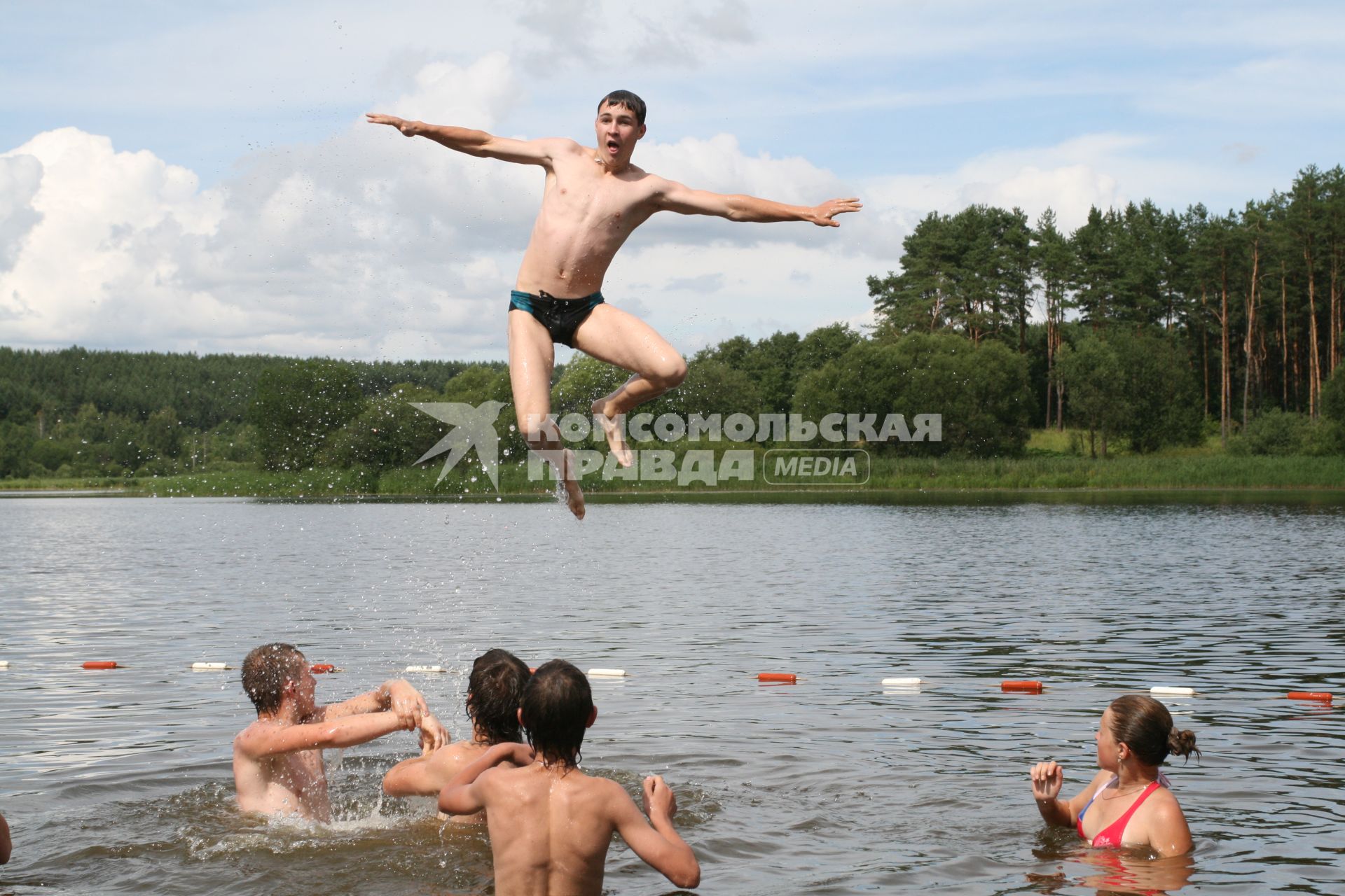 Отдых в лагере. На снимке: молодые люди купаются в реке.