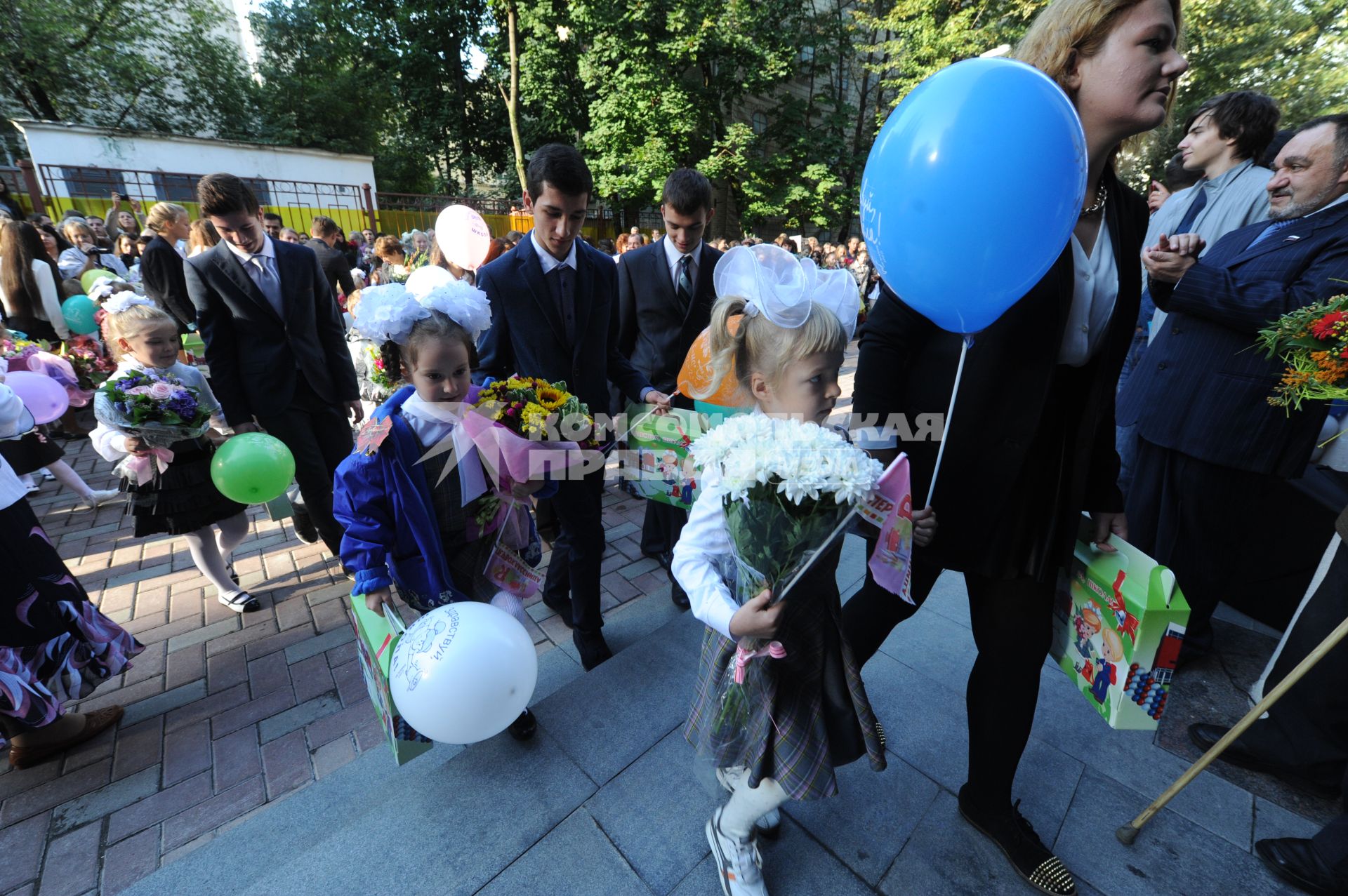 День знаний. На снимке:  ученики старших классов ведут певоклассников в школу.