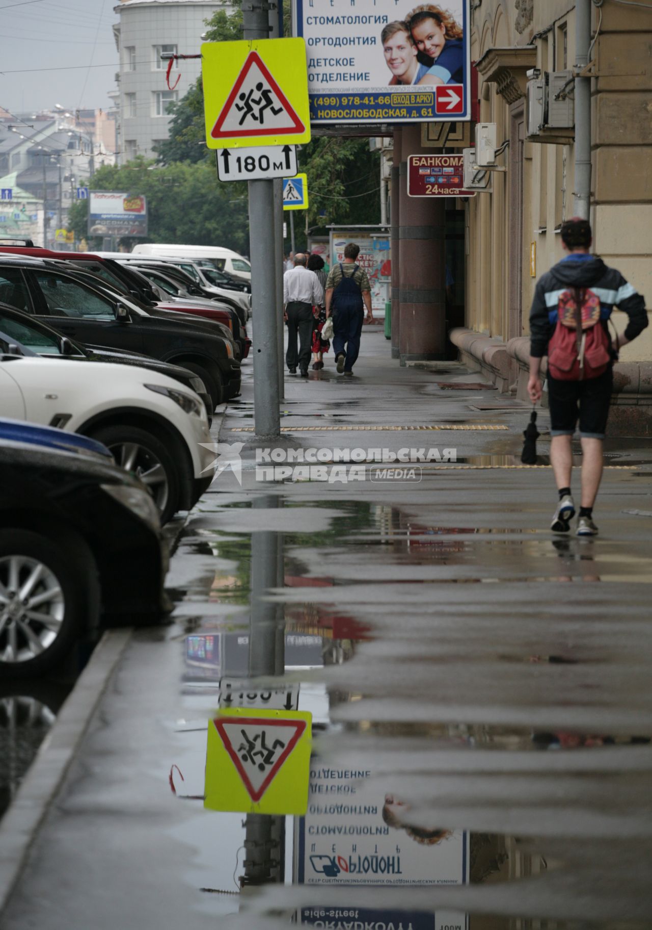 Город после дождя. На снимке: прохожие и автомобили.