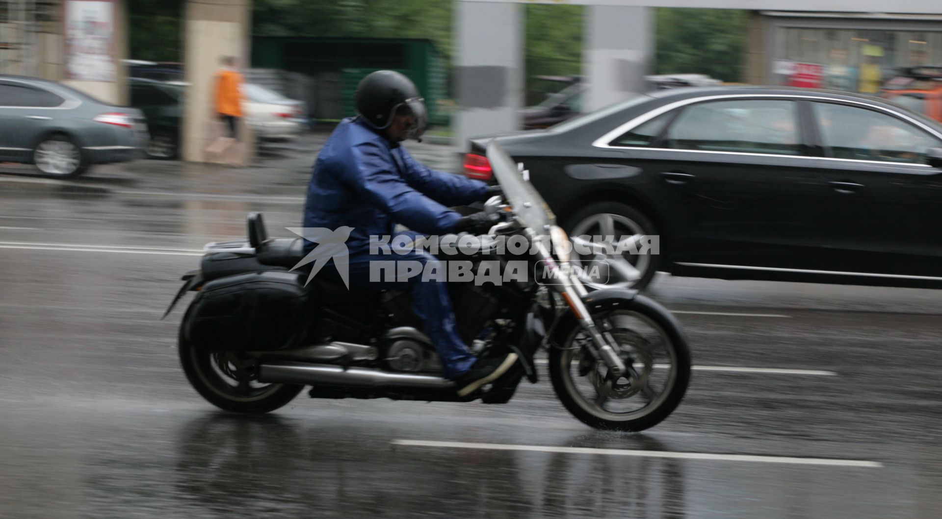 Дождь в городе. На снимке: мотоциклист на мокрой дороге.