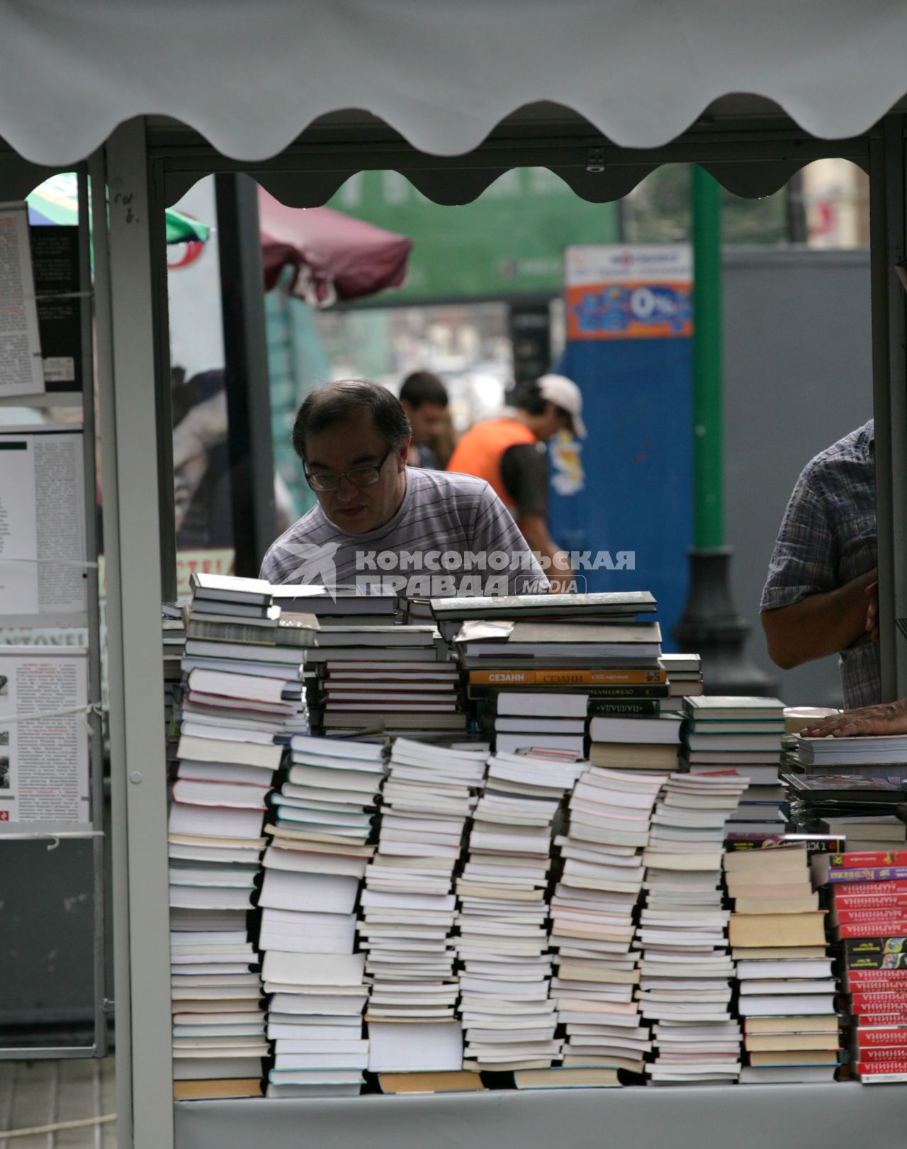 Продажа книг. На снимке: мужчина рассматривает ассортмент книг.