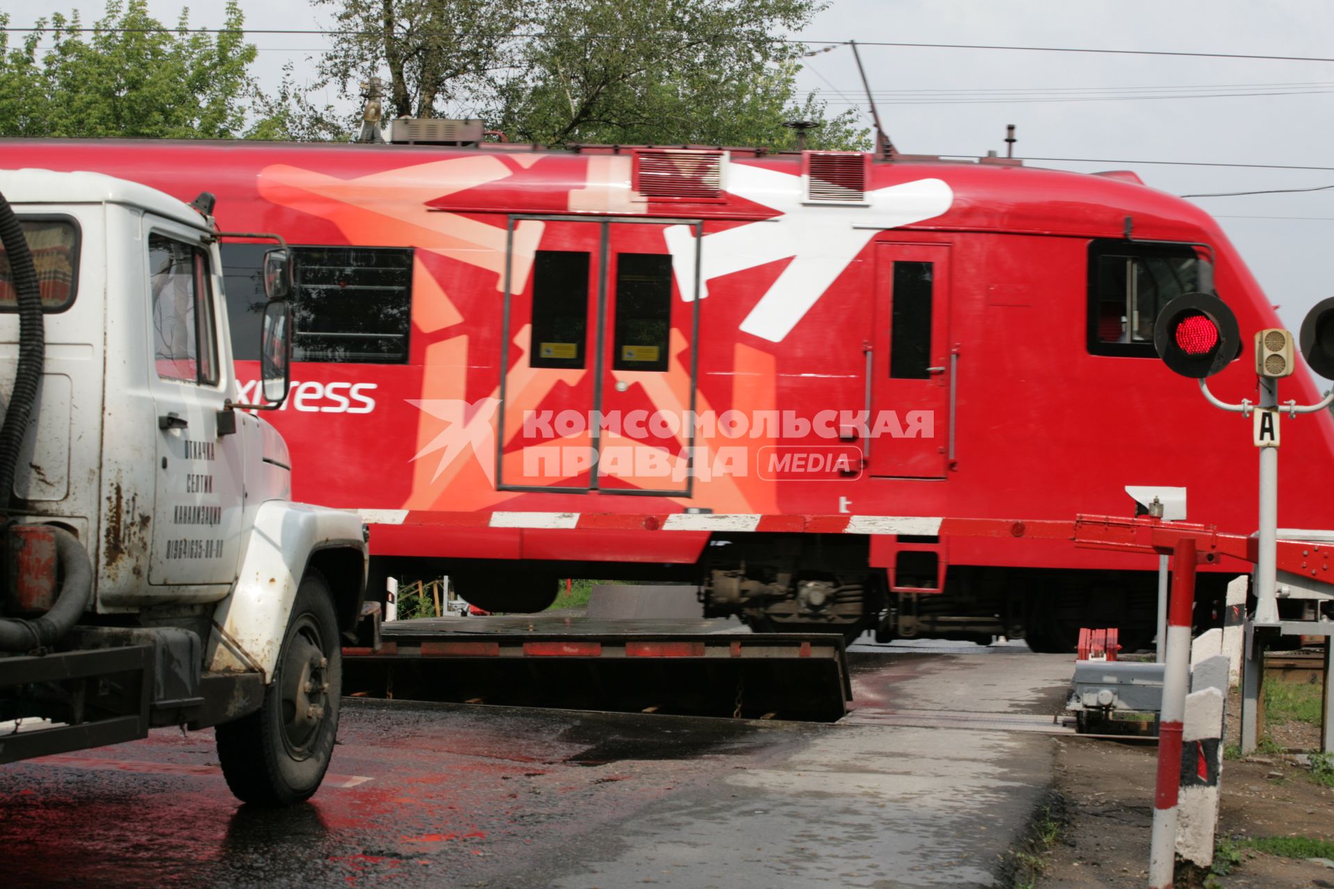 Железнодорожный переезд. На снимке: электропоезд  `Аэроэкспресс` и автомобиль