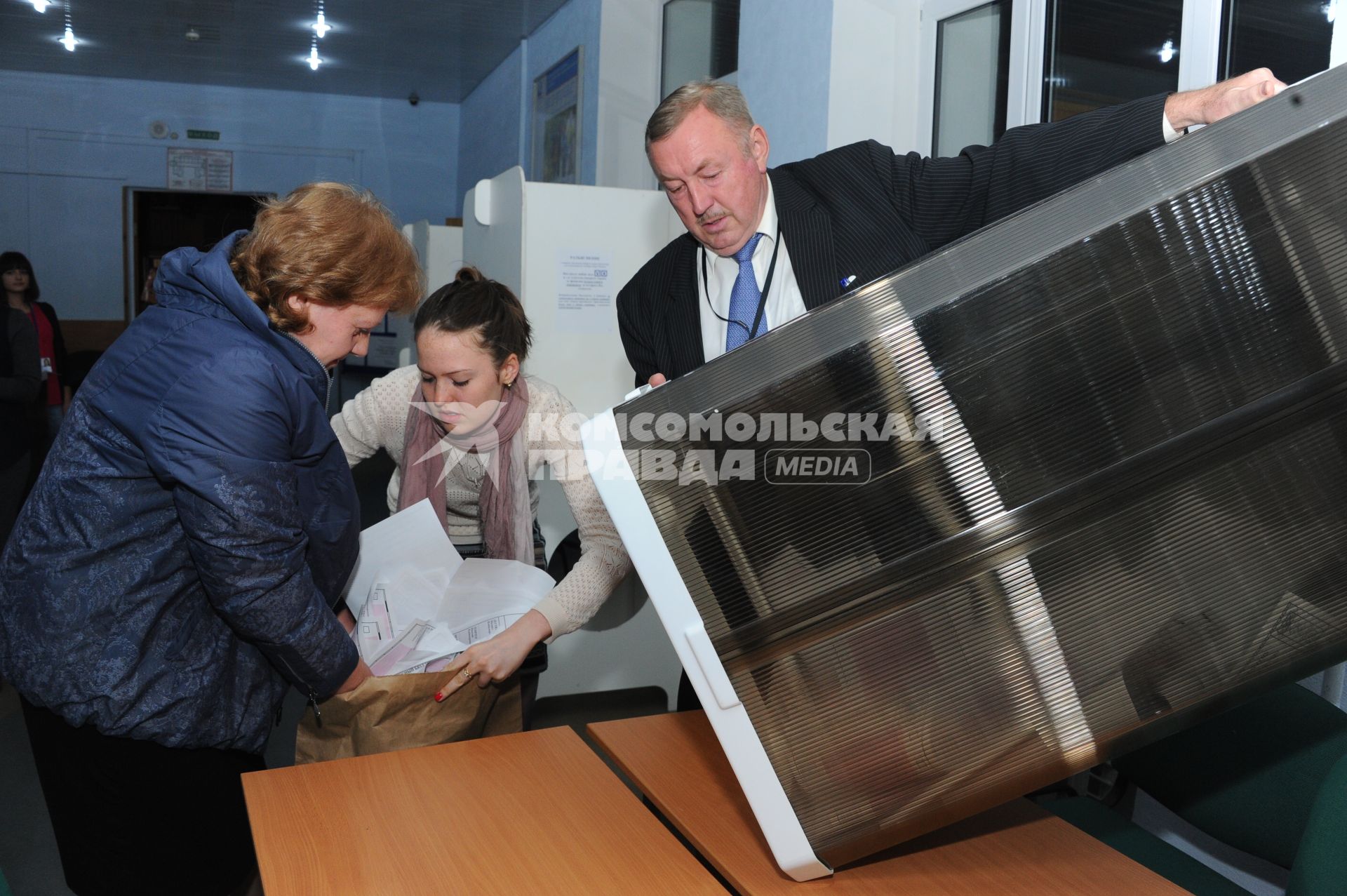 Выборы мэра Москвы 2013. Избирательный участок № 182. На снимке: сотрудники избирательной комиссии открыли урну с бюллетенями.