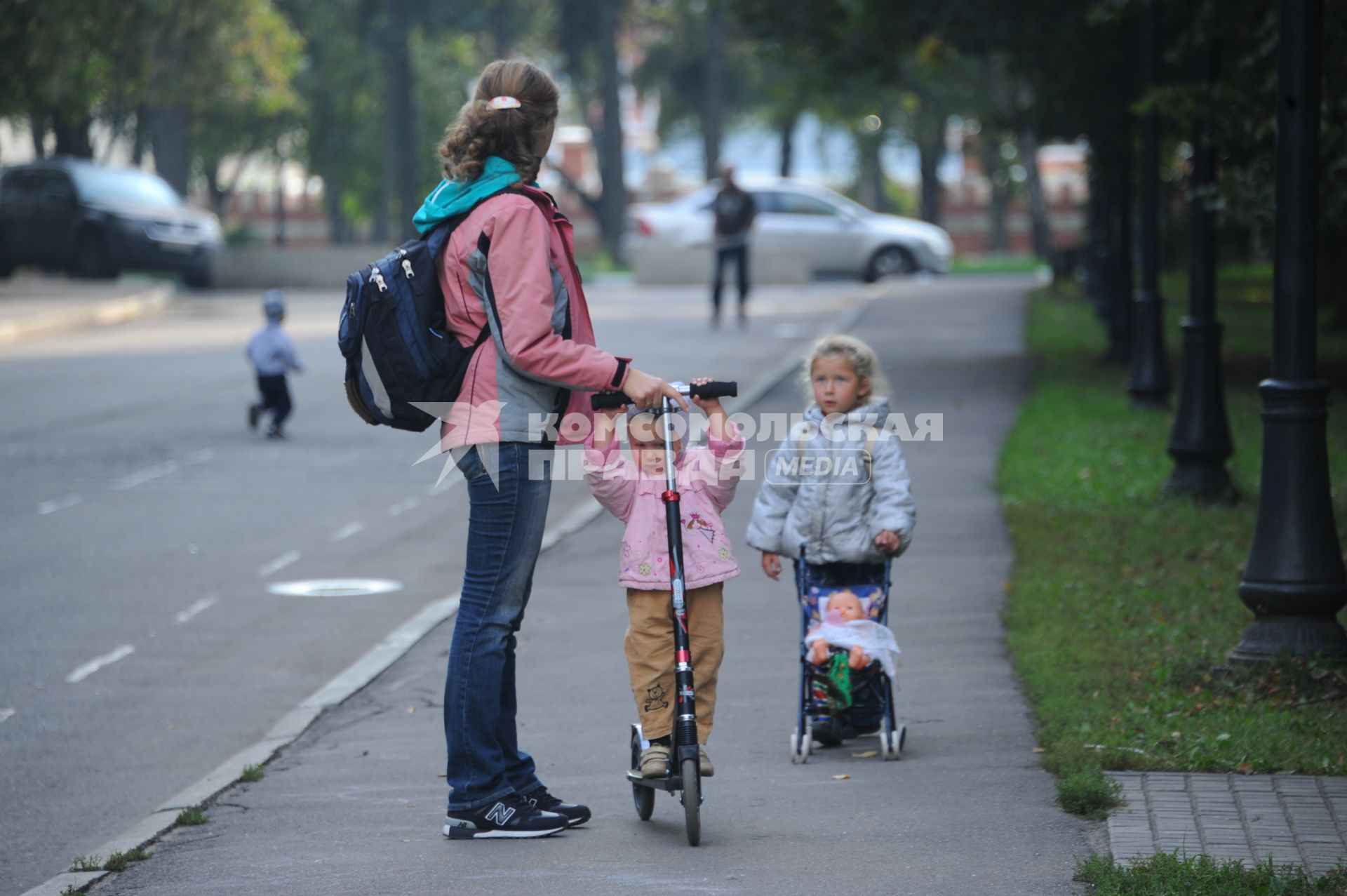 Мама с детьми гуляют в Петровском парке.