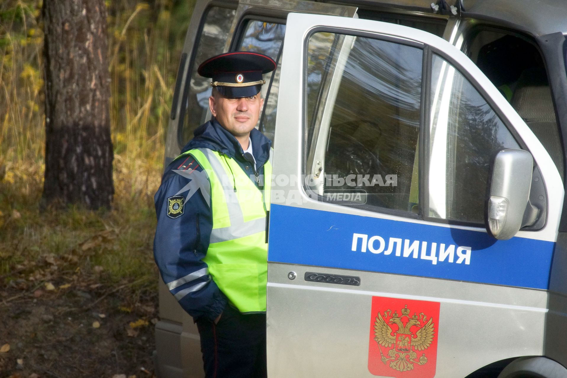 Полицейский около служебного автомобиля.