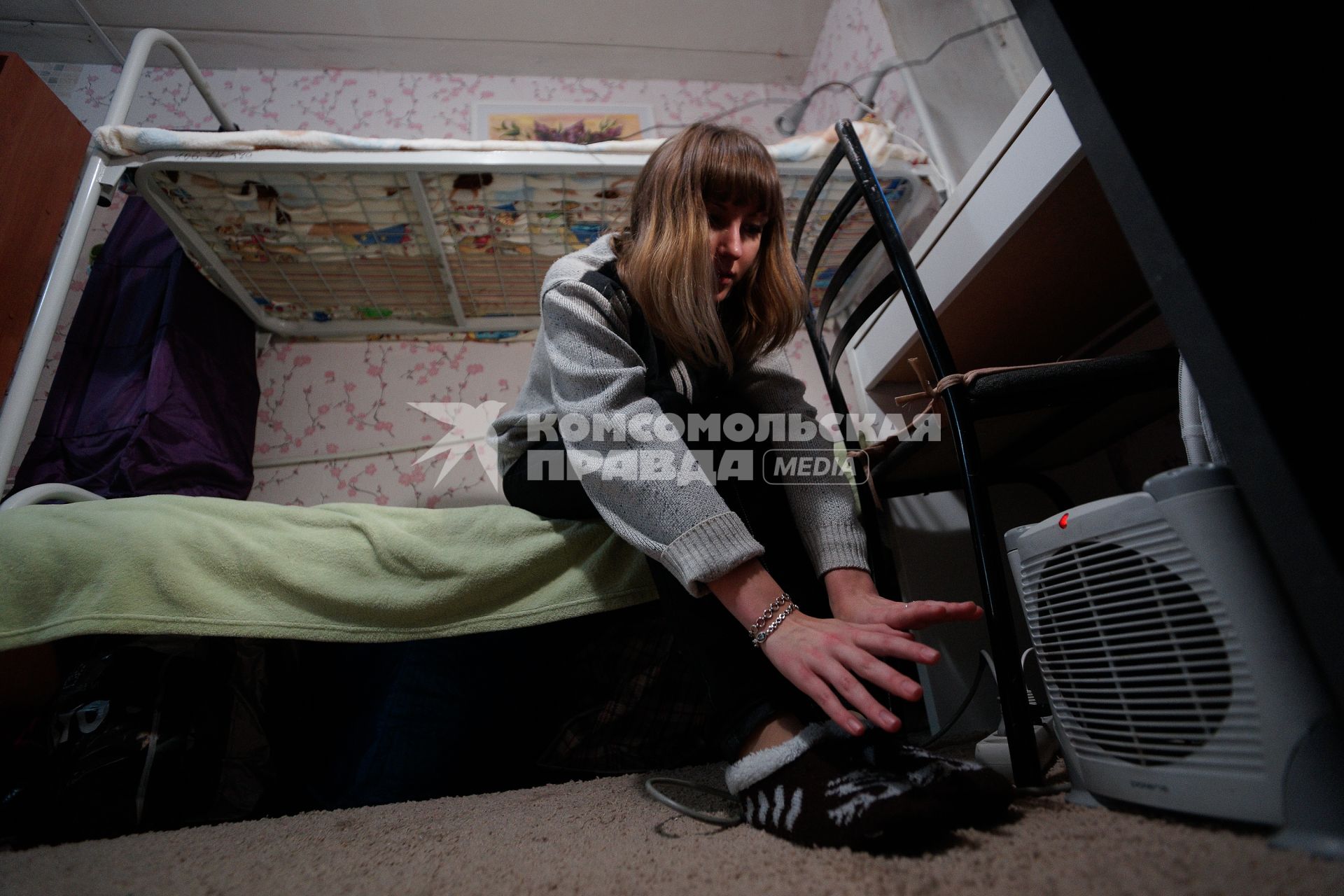 Студенческое общежитие в Екатеринбурге. На снимке: девушка греет руки у обогревателя.