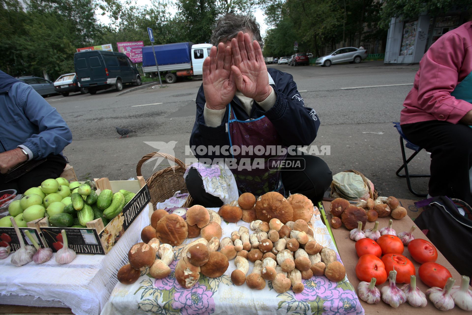 Продажа грибов.. На снимке: торговец закрывает лицо руками.