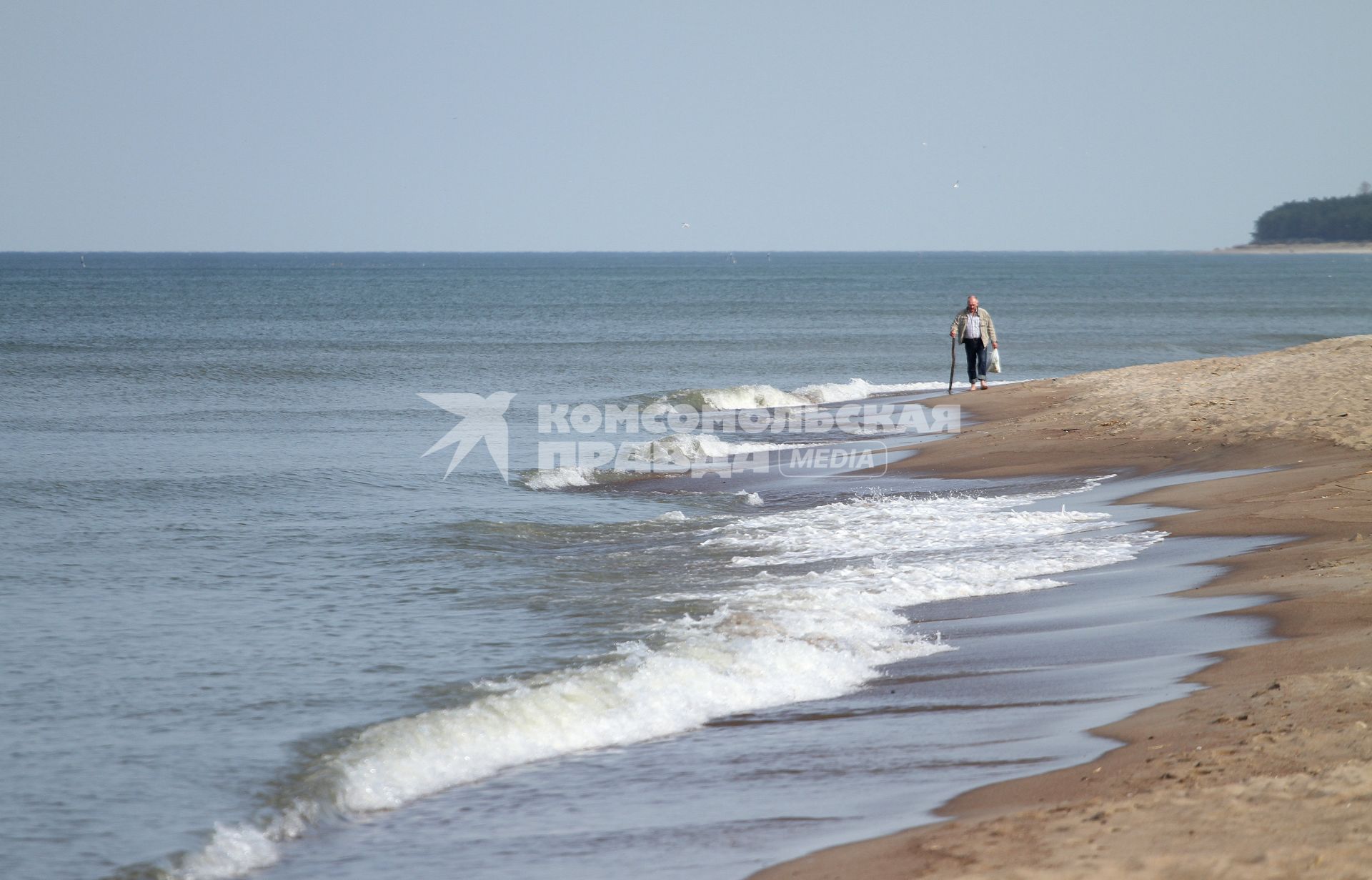 Мужчина с тростью идет по берегу Балтийского моря