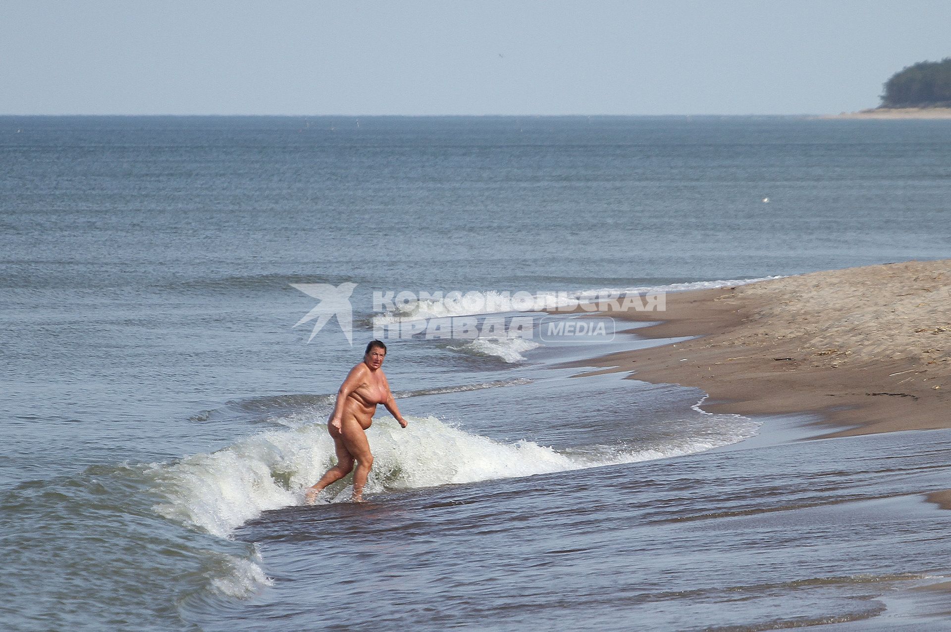 Женщина купается в море.