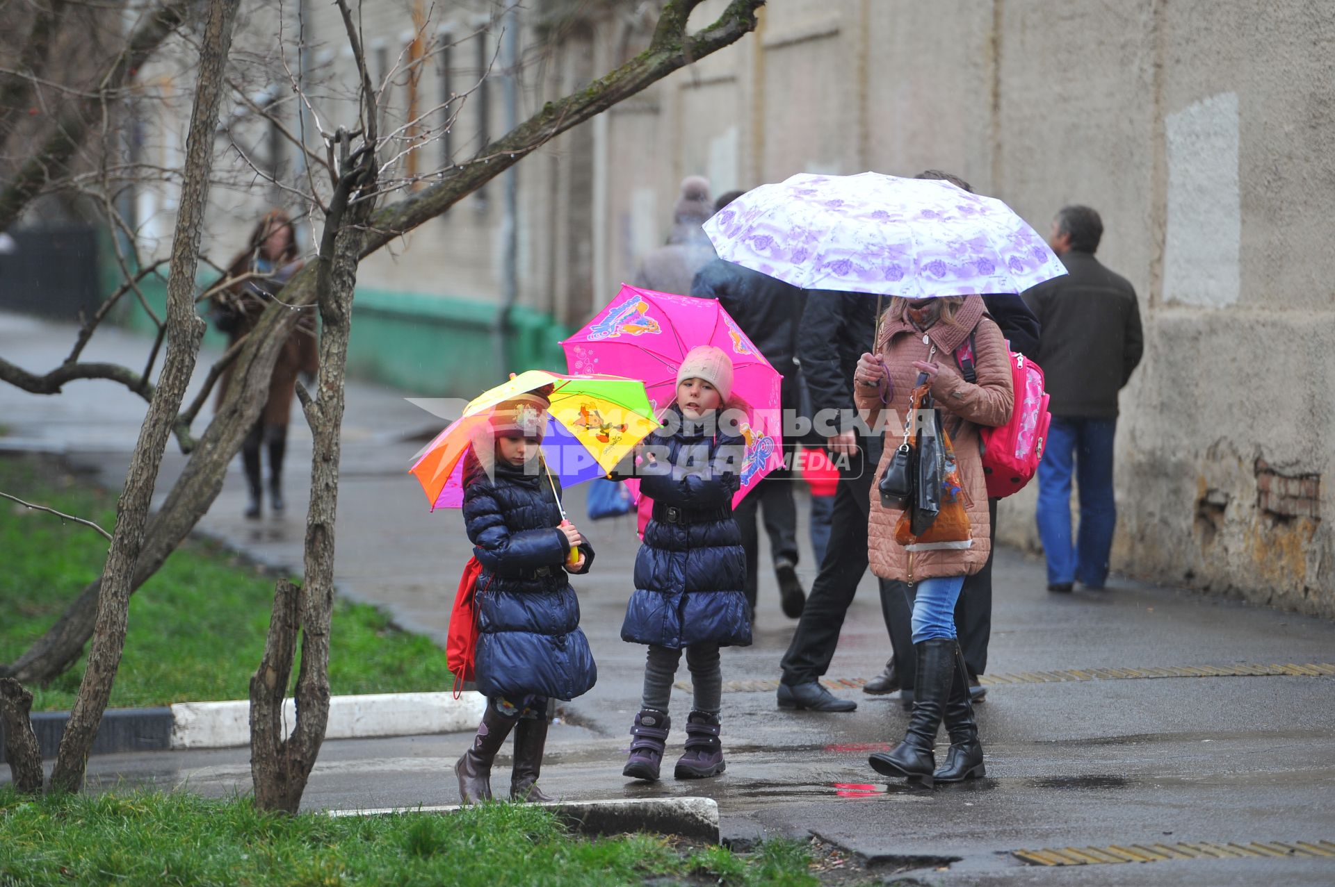 Дождь в городе. На снимке: женщина и девочки под зонтами.