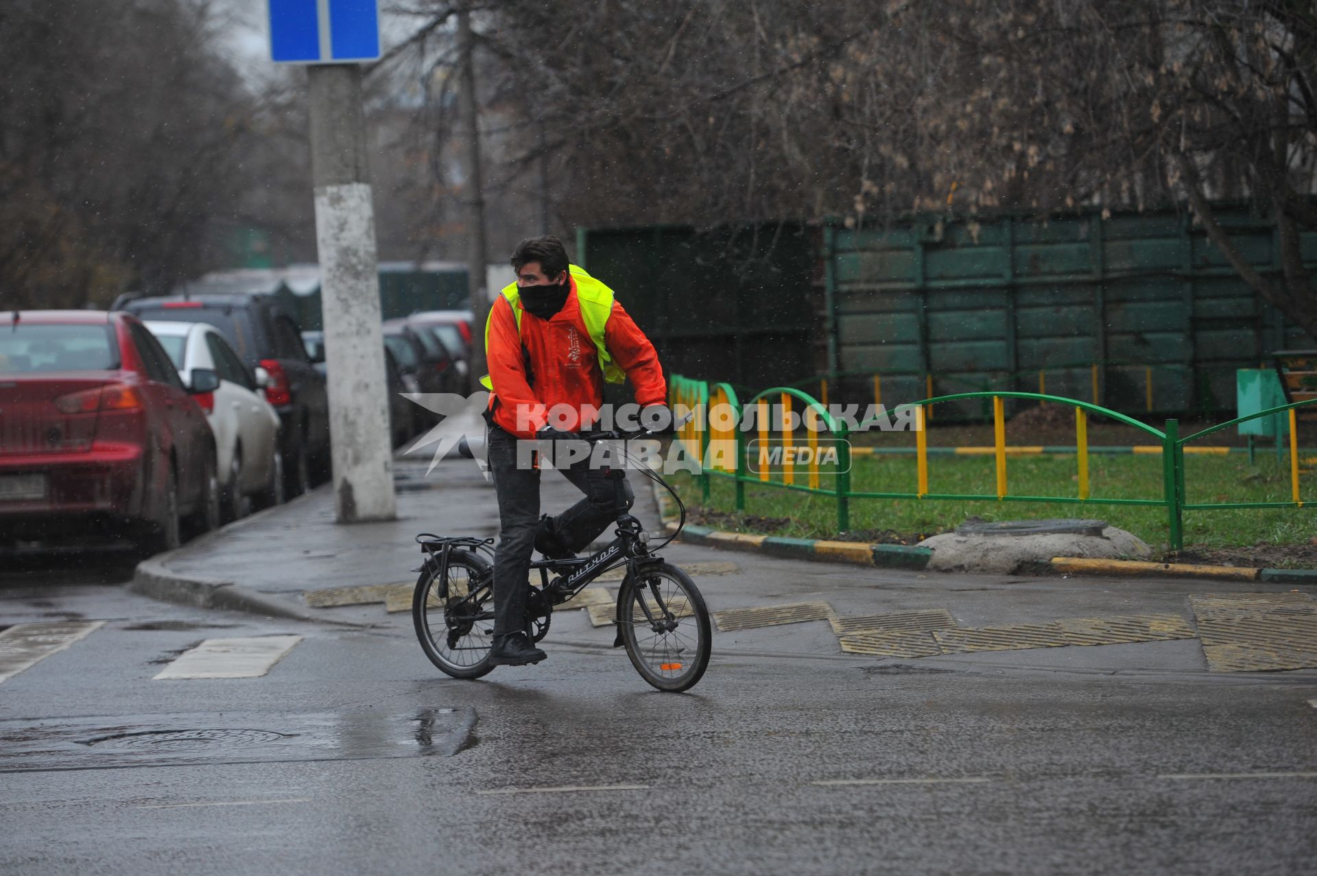 Дождь в городе. На снимке: велосипедист на дороге.