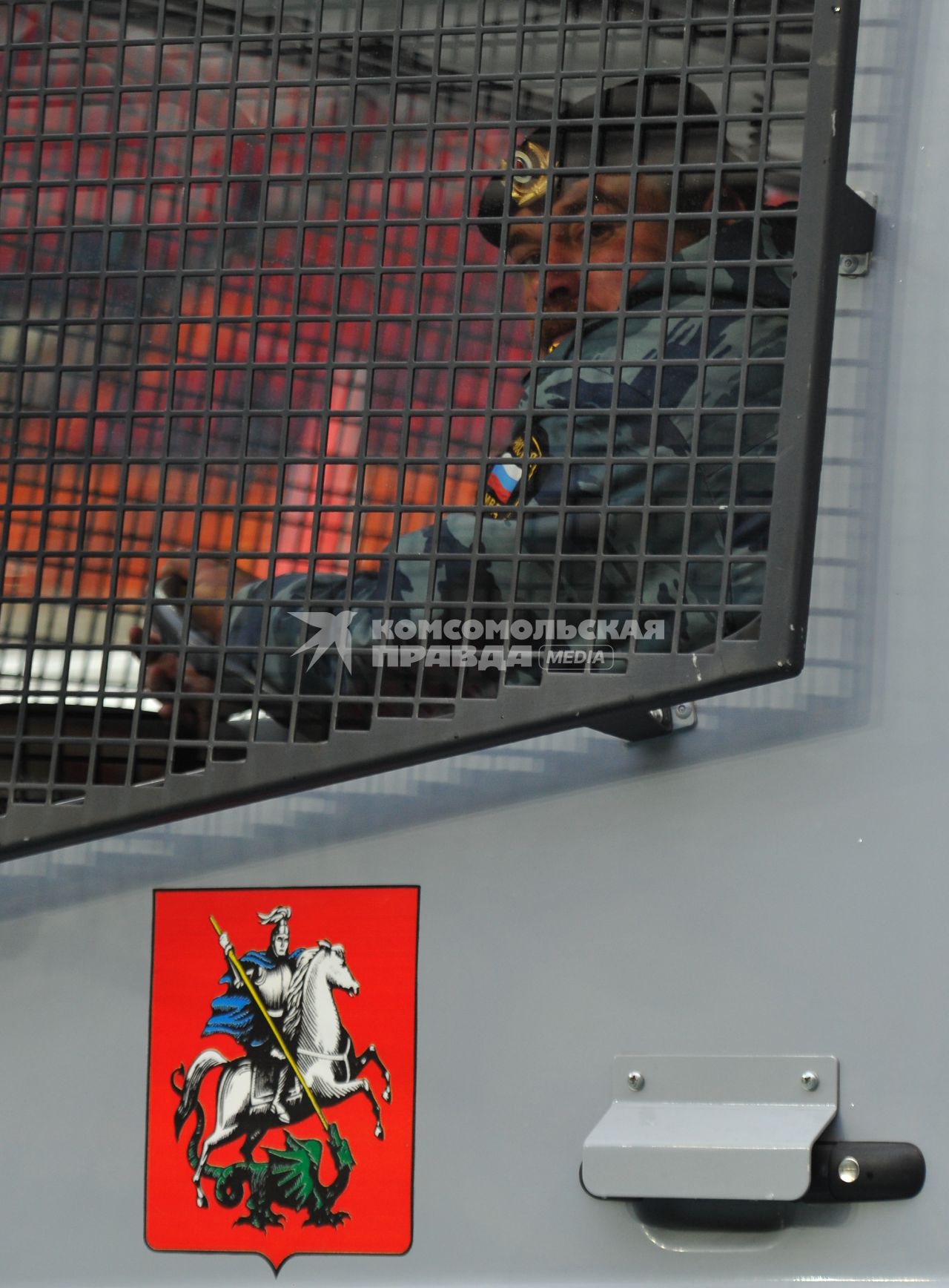 СК `Лужники`.  Спортивный праздник московской полиции. На снимке:  сотрудник ОМОНа за решеткой спецавтомобиля.