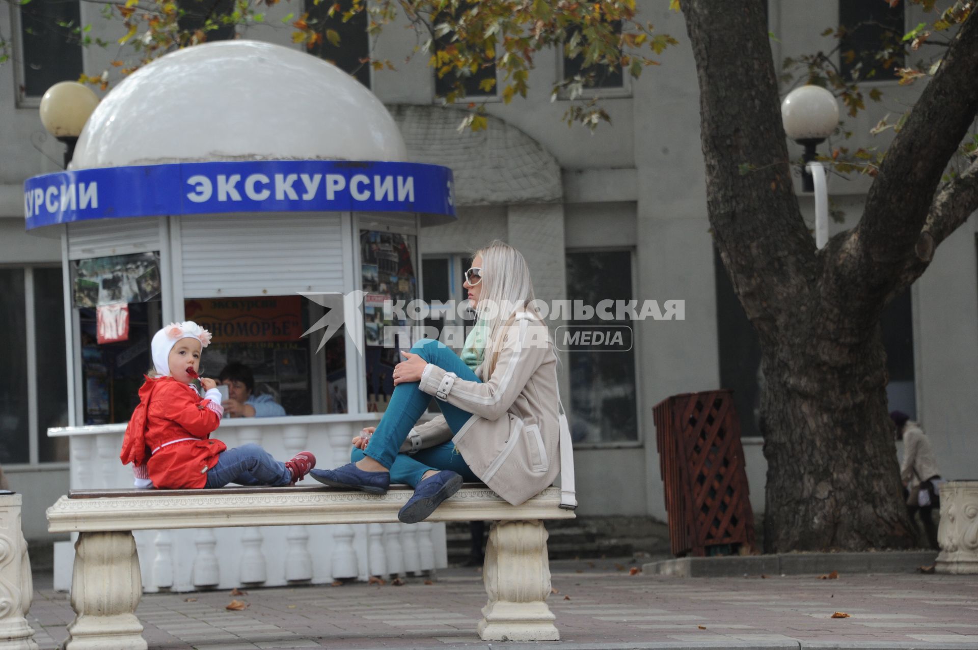 Геленджик. На снимке: девушка с ребенком сидят на скамейке.