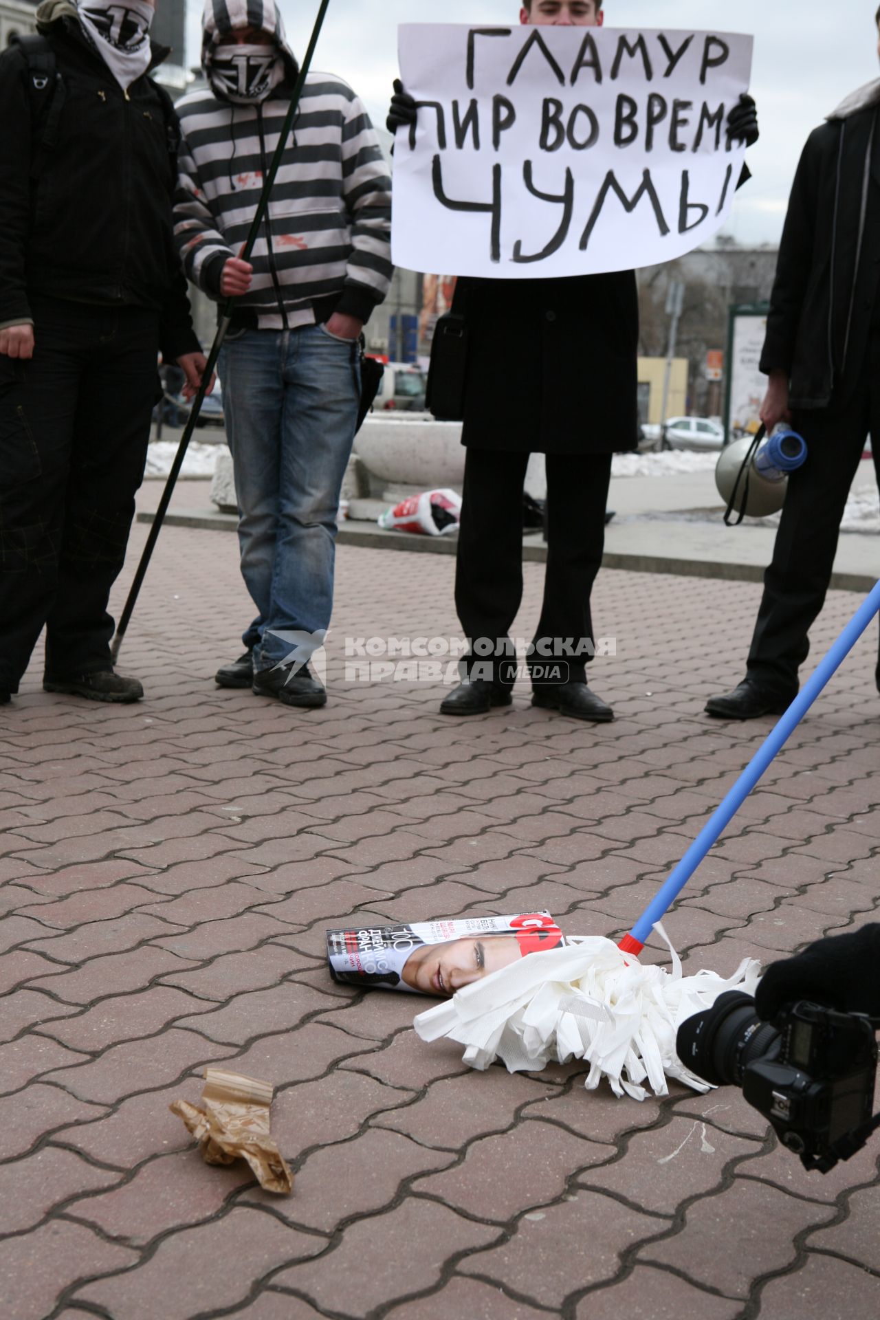 Митинг против засилья гламура в СМИ, организованный политической организацией `Евразийский союз молодежи` на Триумфальной площади. На снимке: активист держит плакат `Гламур-пир во время чумы`.