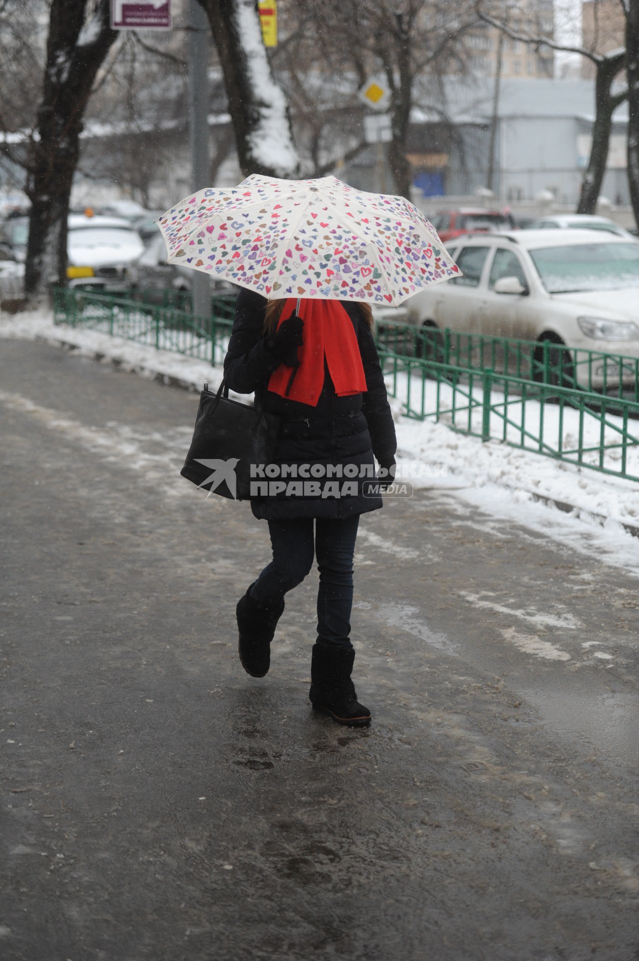 Тающий снег в Москве. На снимке: девушка идет под зонтом.