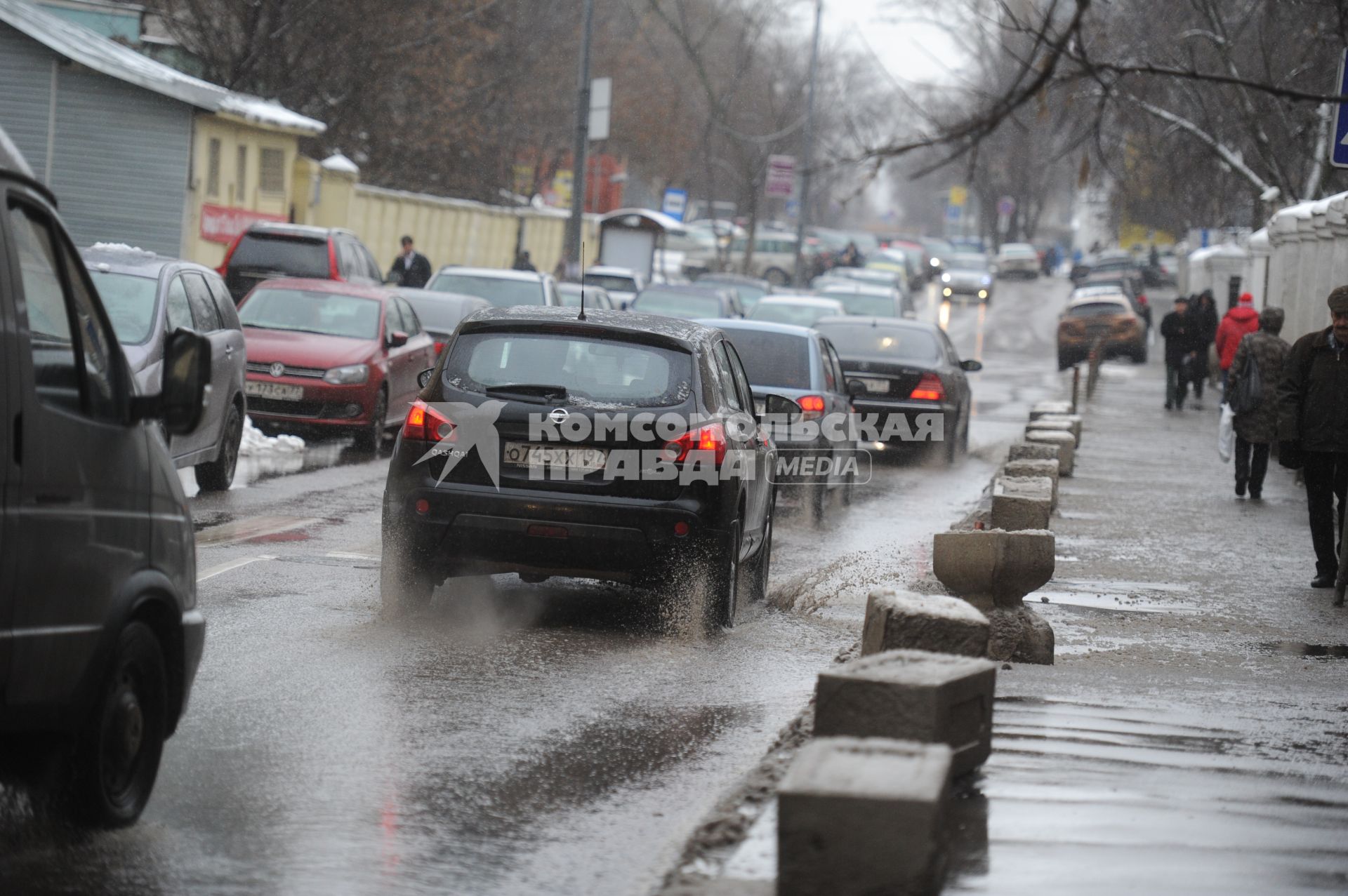 Тающий снег в Москве. На снимке: автомобили едут по лужам.