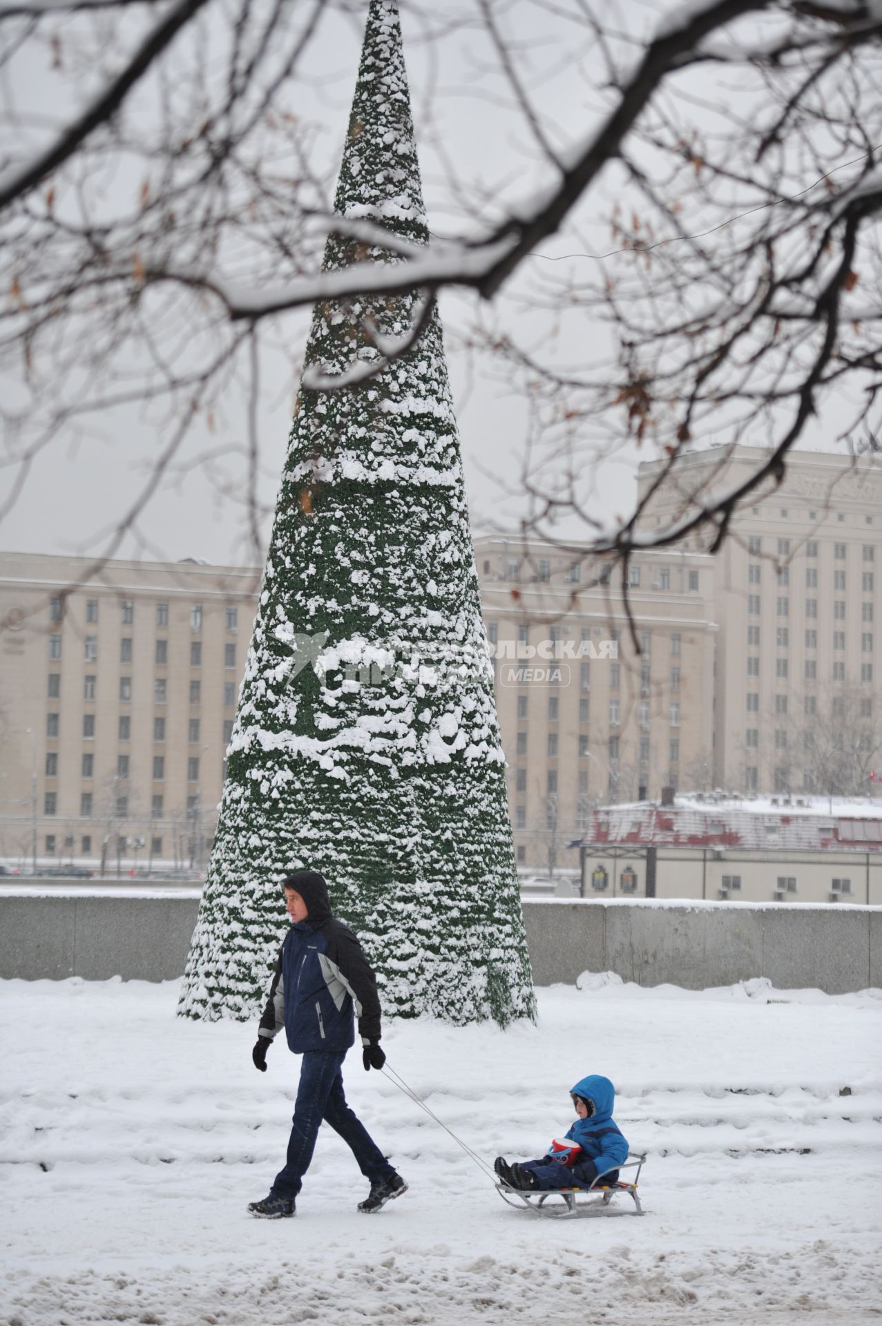 Снег в Москве. Парк Горького. На снимке: мужчина катает ребенка на санках.