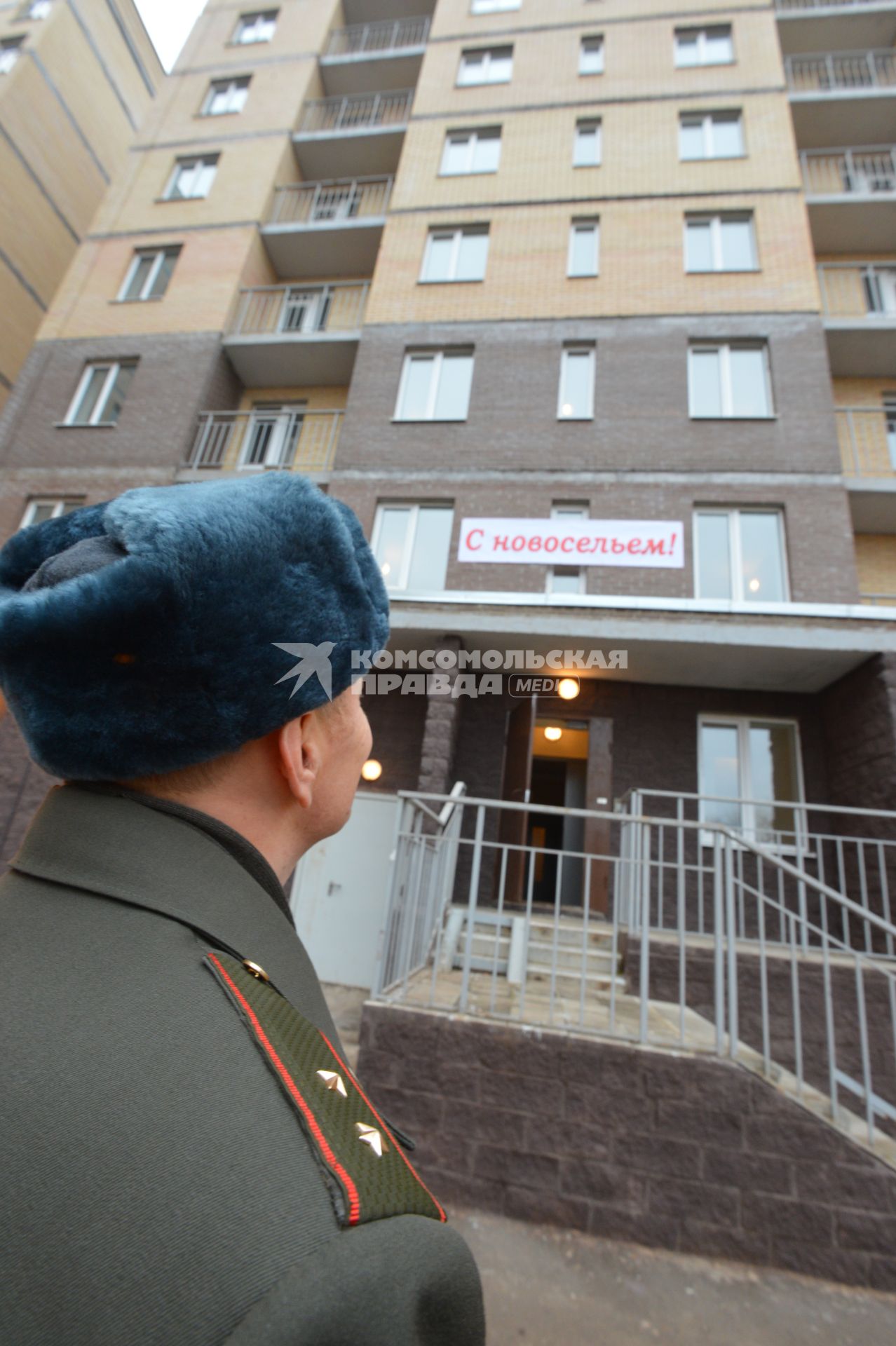 Жилье военным. Офицер перед подъездом дома.