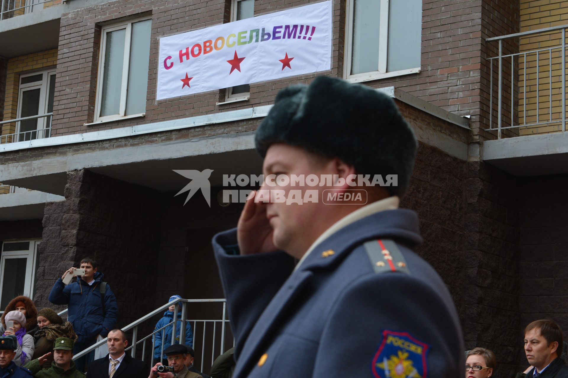 Жилье военным. Офицер перед подъездом дома.