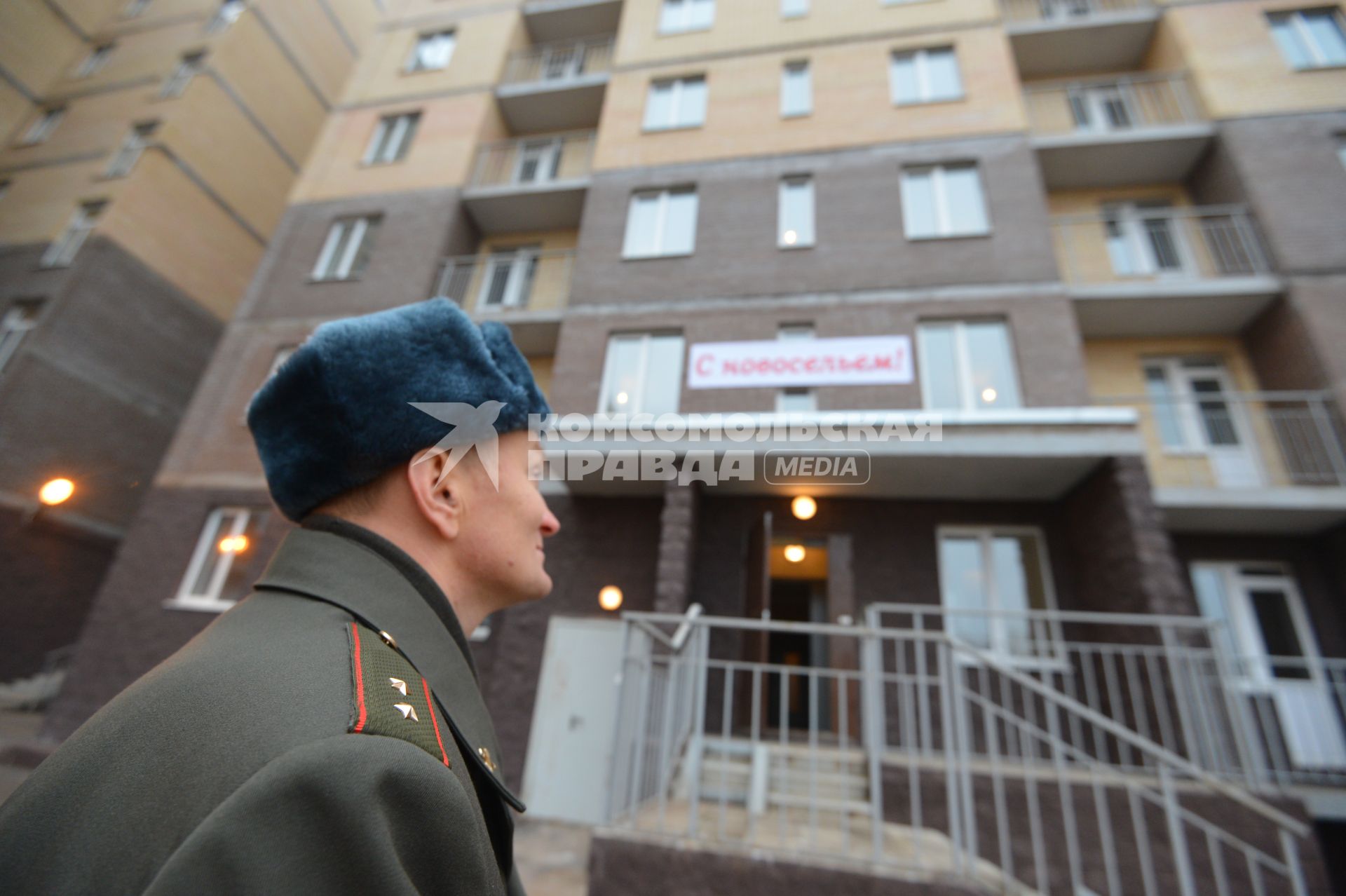 Жилье военным. Офицер перед подъездом дома.