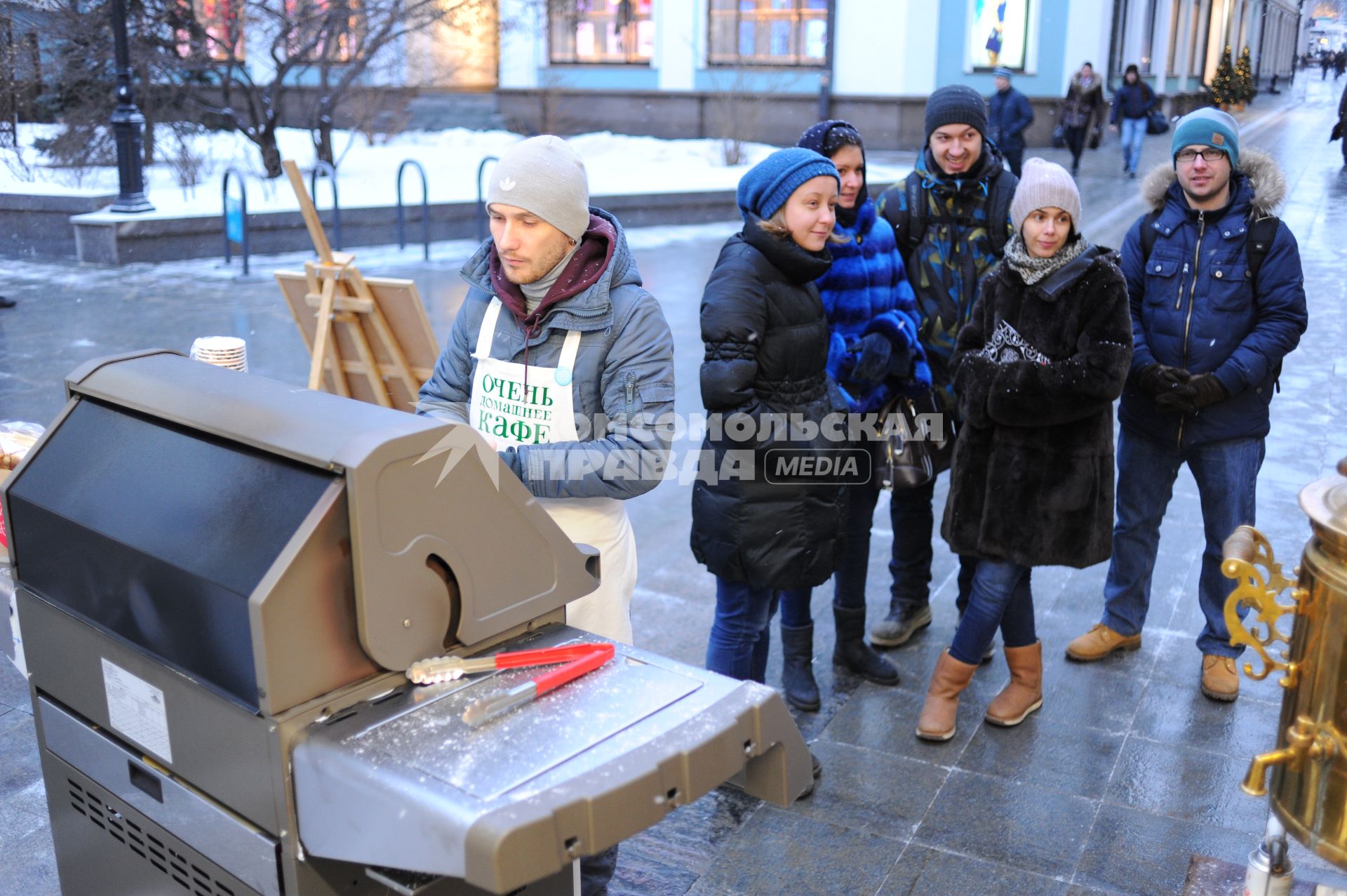 Станция `Теплое место` открылась в Столешниковом переулке. На снимке: продавец в фартуке с надписью `Очень домашнее кафе`.