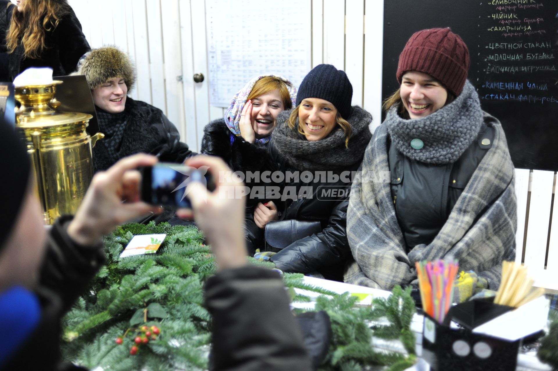 Станция `Теплое место` открылась в Столешниковом переулке. На снимке: девушки фотографируются за столом.