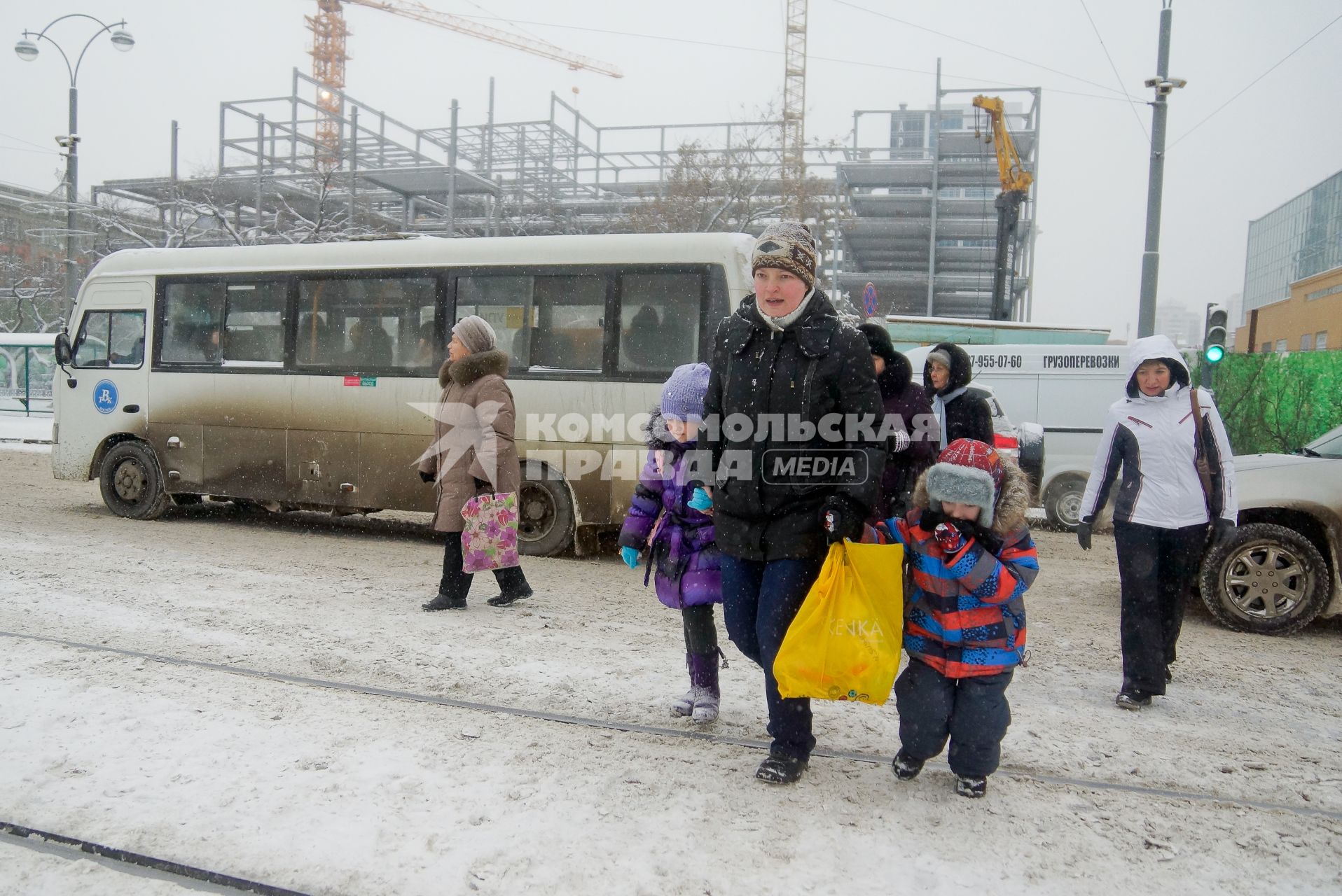 Снегопад в Екатеринбурге. На снимке: женщина с детьми переходит дорогу.
