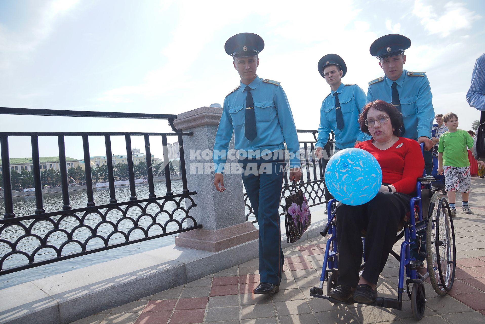 День города в Екатеринбурге. На снимке: курсанты везут женщину на инвалидной коляске.